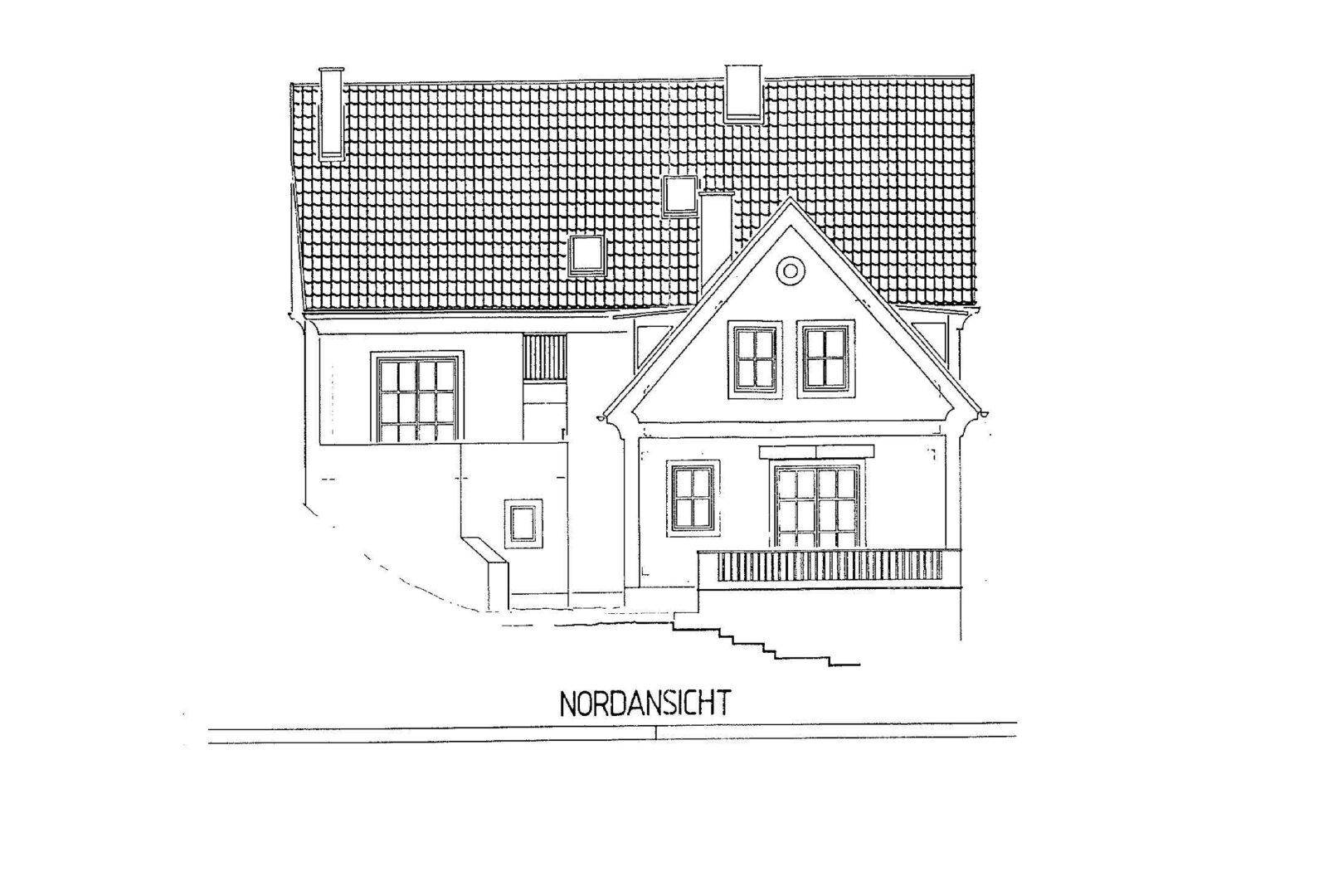 Nordansicht des Gebäudes mit Satteldach, Fenstern und einem kleinen Balkon.
