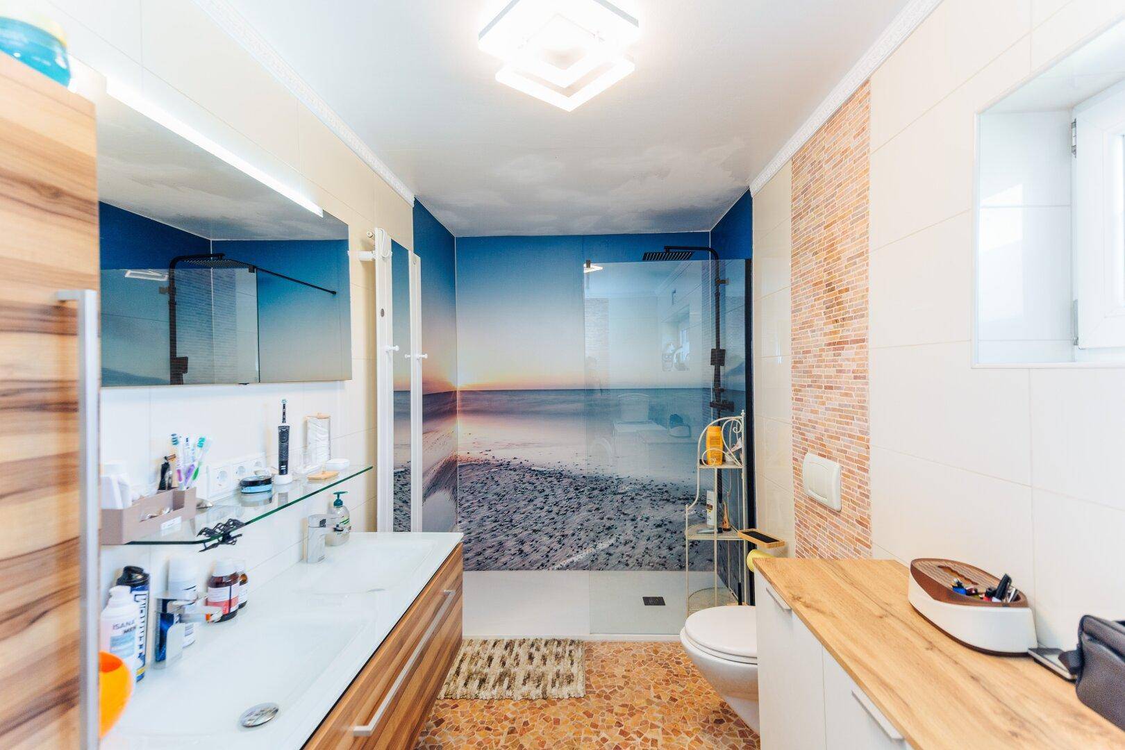 Modernes Badezimmer mit begehbarer Dusche, Doppelwaschbecken und einem Fenster für Tageslicht.