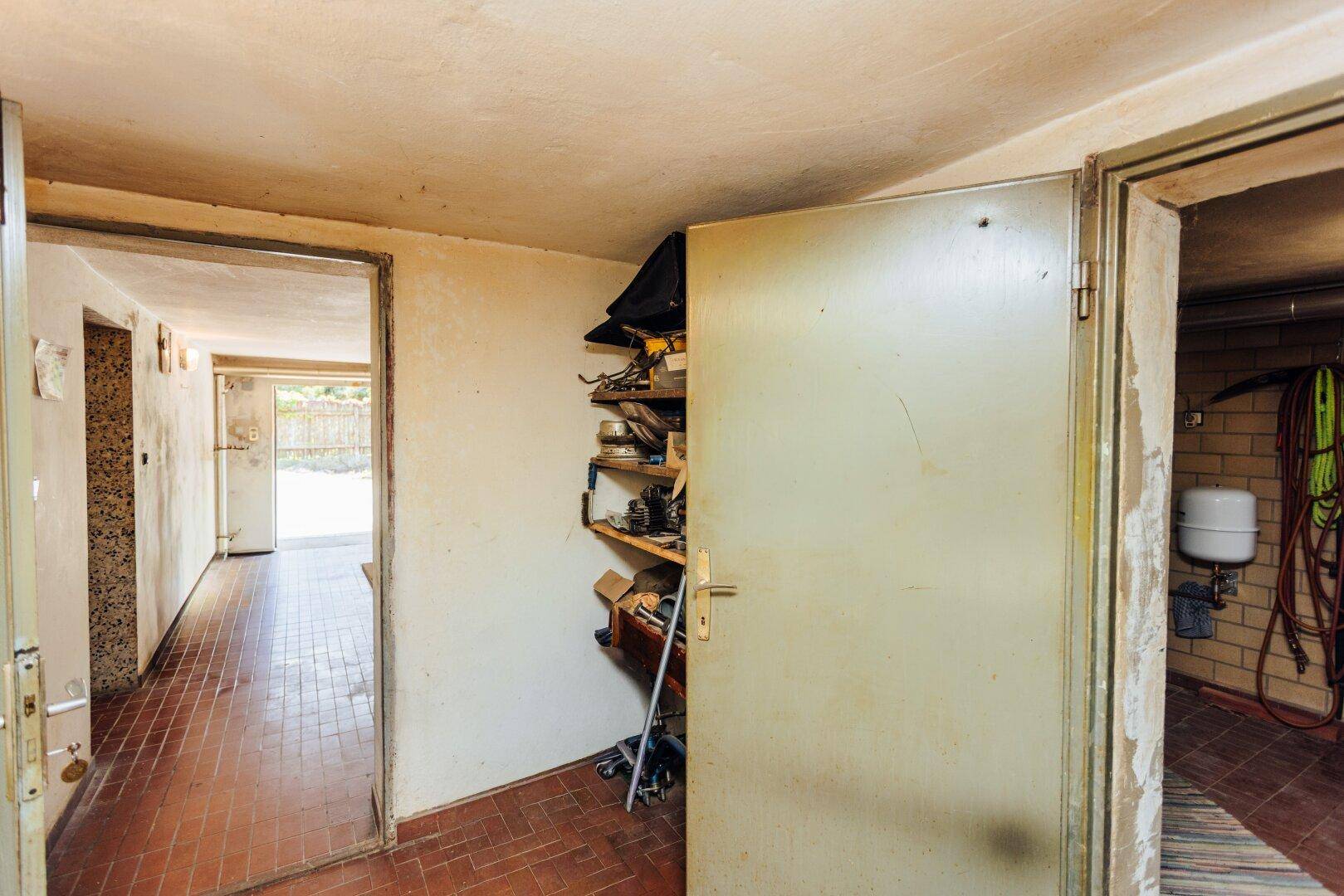 Praktischer Abstellraum im Keller mit Regalen und Zugang zu weiteren Kellerräumen.