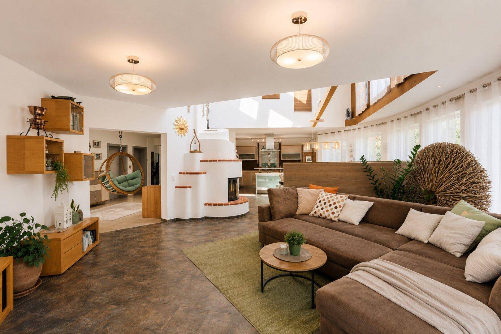 Geräumiges Wohnzimmer mit großem Ecksofa, Kamin und Blick in den offenen Wohnbereich.