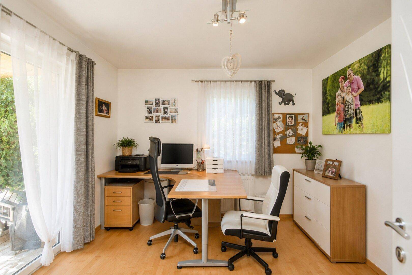 Helles Arbeitszimmer mit Schreibtisch, Bürostühlen und Zugang zur Terrasse.