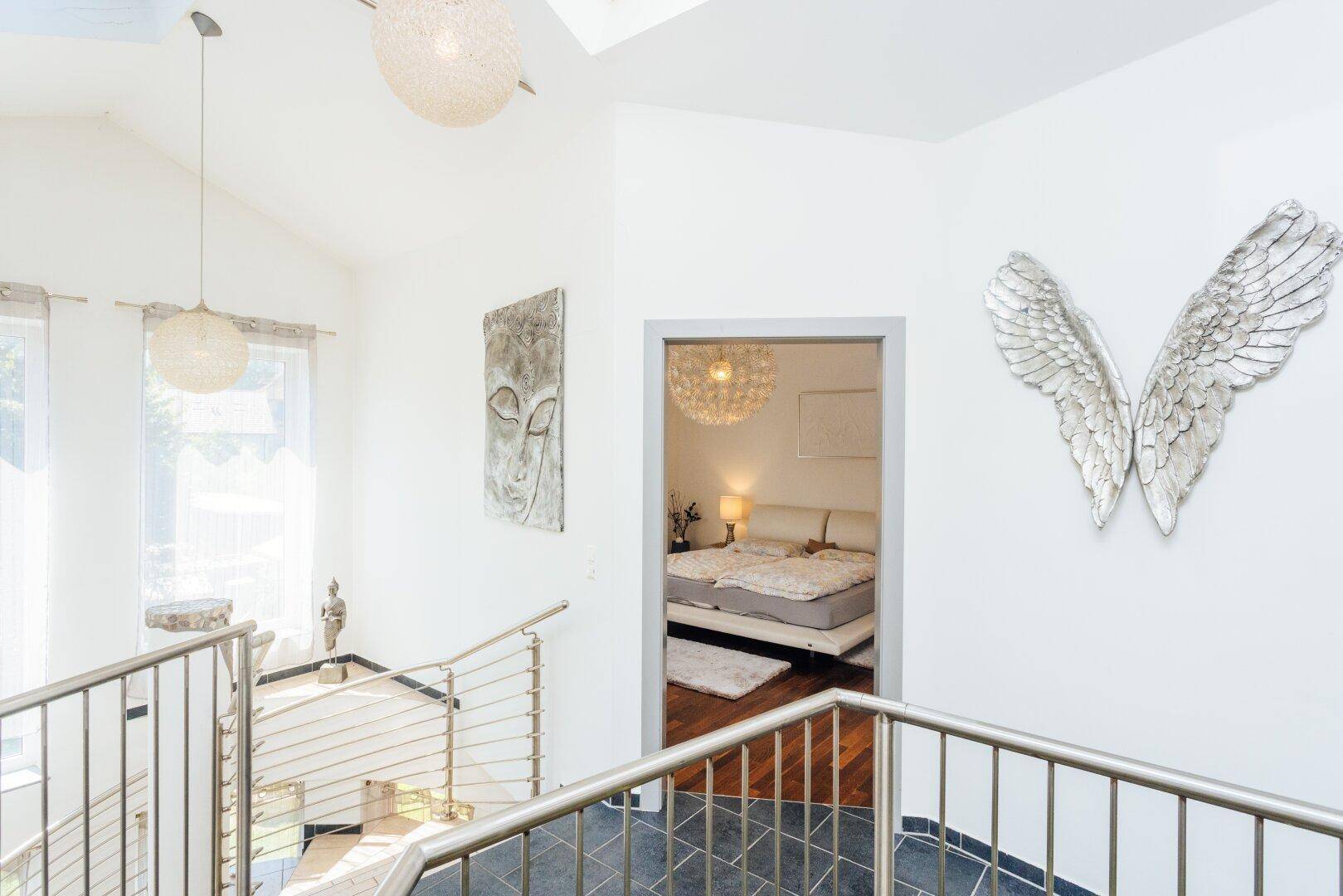 Helle Galerie mit Blick in ein Schlafzimmer und dekorativen Elementen.