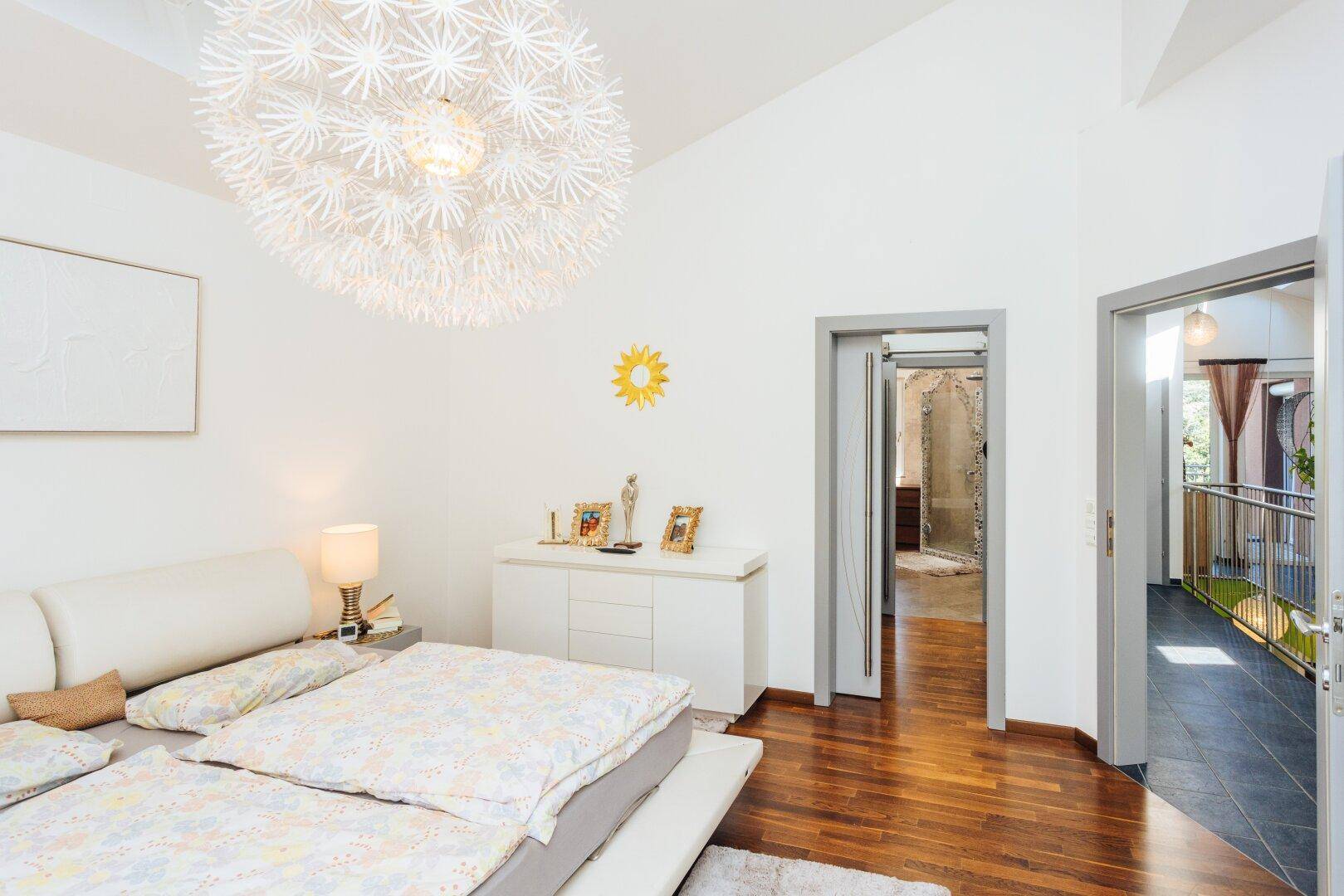 Schlafzimmer mit Zugang zu einem begehbaren Kleiderschrank und weiteren Räumen.