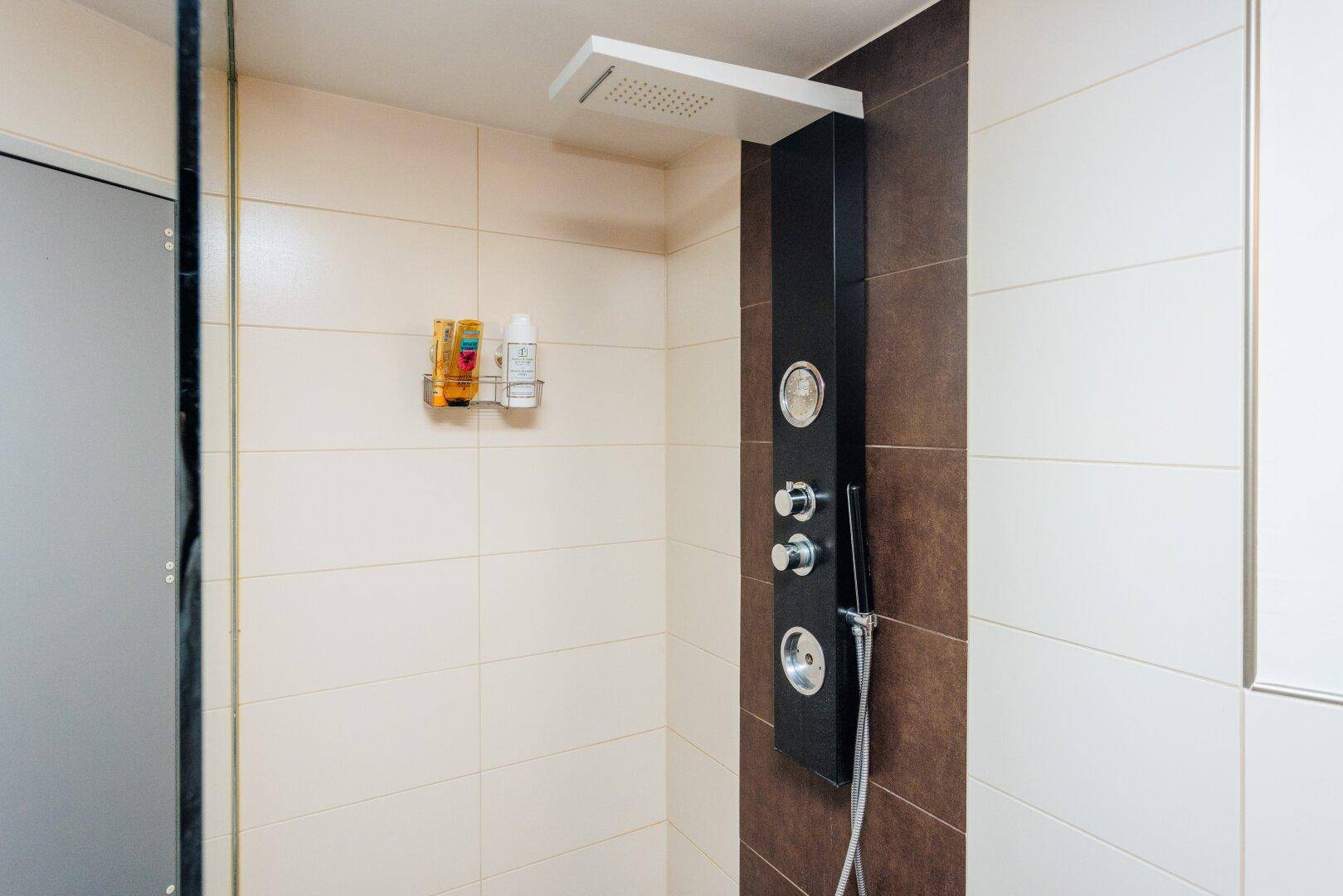 Moderne Duschkabine mit Regendusche und integriertem Duschpaneel.
