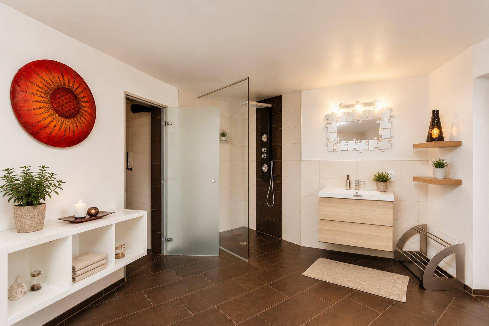 Modernes Badezimmer mit großformatigen Fliesen, Waschtisch und begehbarer Dusche.