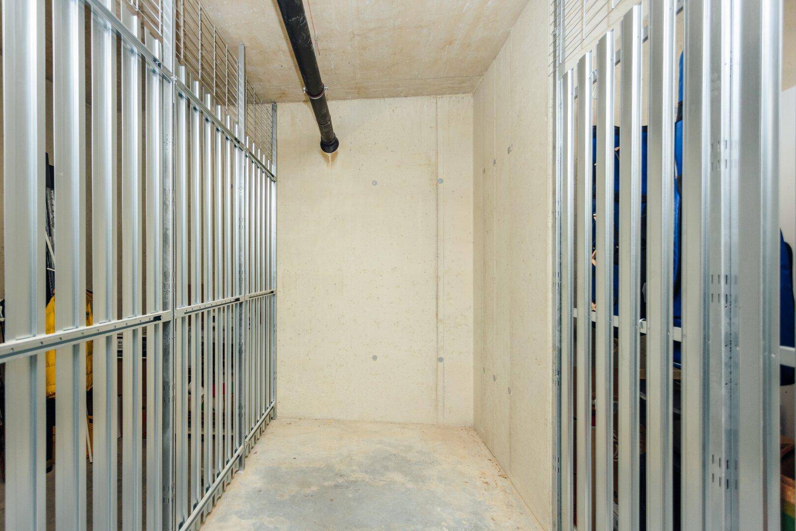 Kellerabteile mit Betonwänden und Metallgittern, bieten zusätzlichen Stauraum für Bewohner.