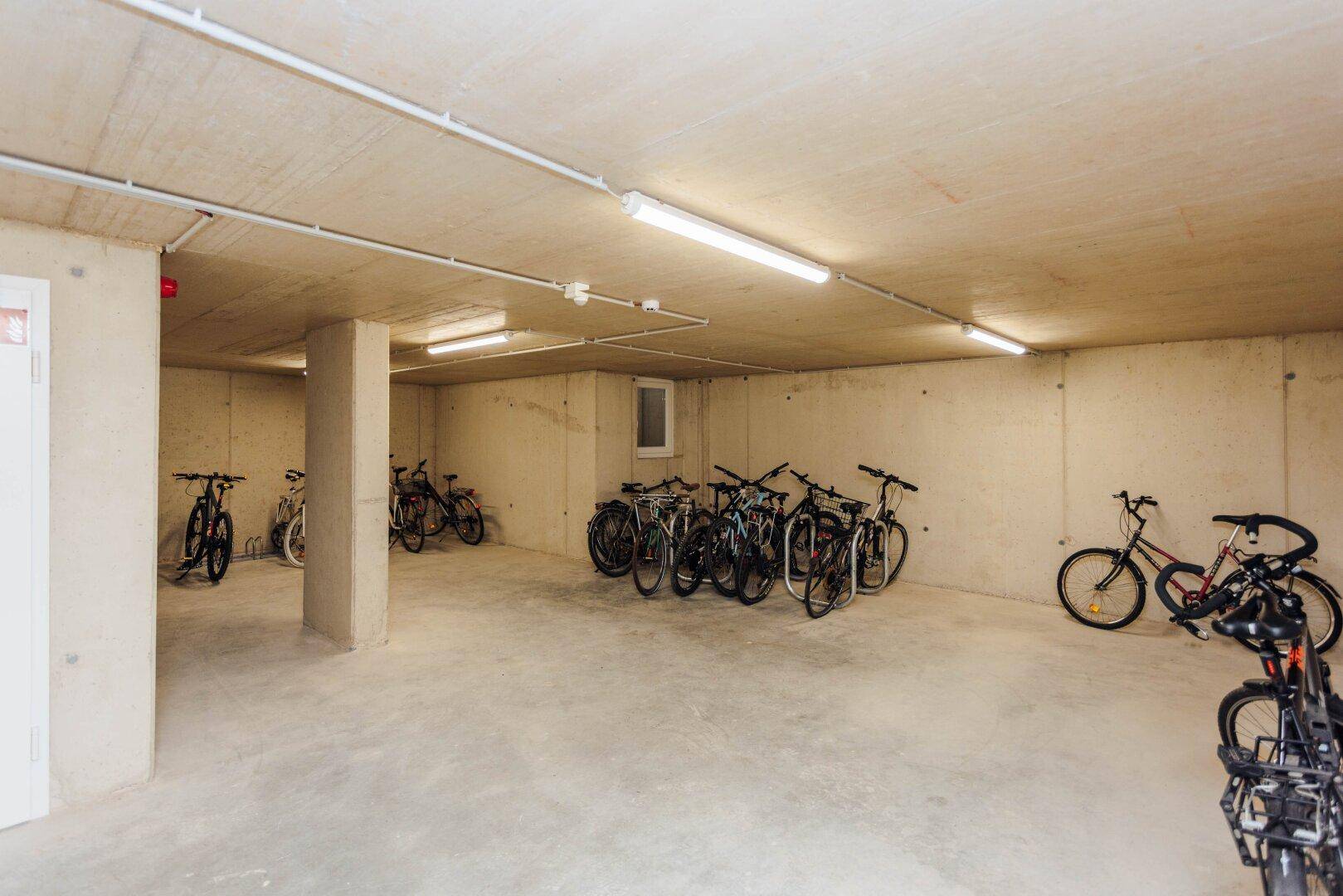Fahrradabstellraum im Untergeschoss mit zahlreichen abgestellten Fahrrädern, gut organisiert.