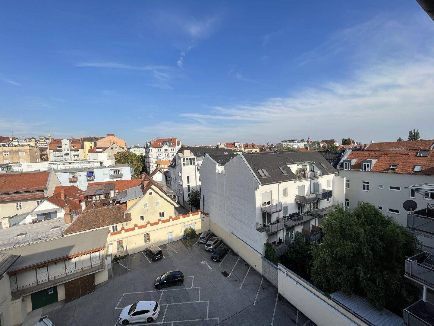 Panoramablick über eine städtische Umgebung mit Parkplätzen und Wohngebäuden.