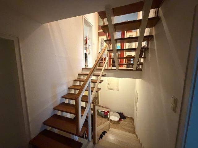 Helle Holztreppe verbindet die verschiedenen Ebenen des Hauses.