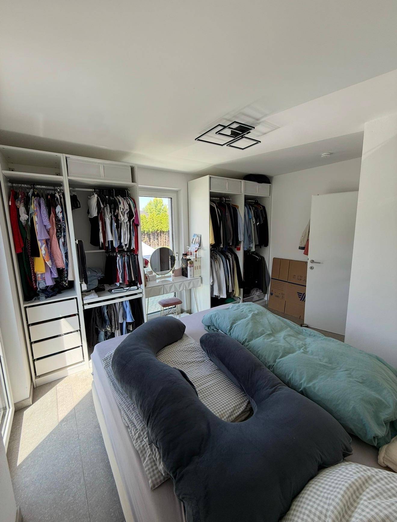 Geräumiges Schlafzimmer mit Einbauschränken, großem Bett und viel natürlichem Licht.