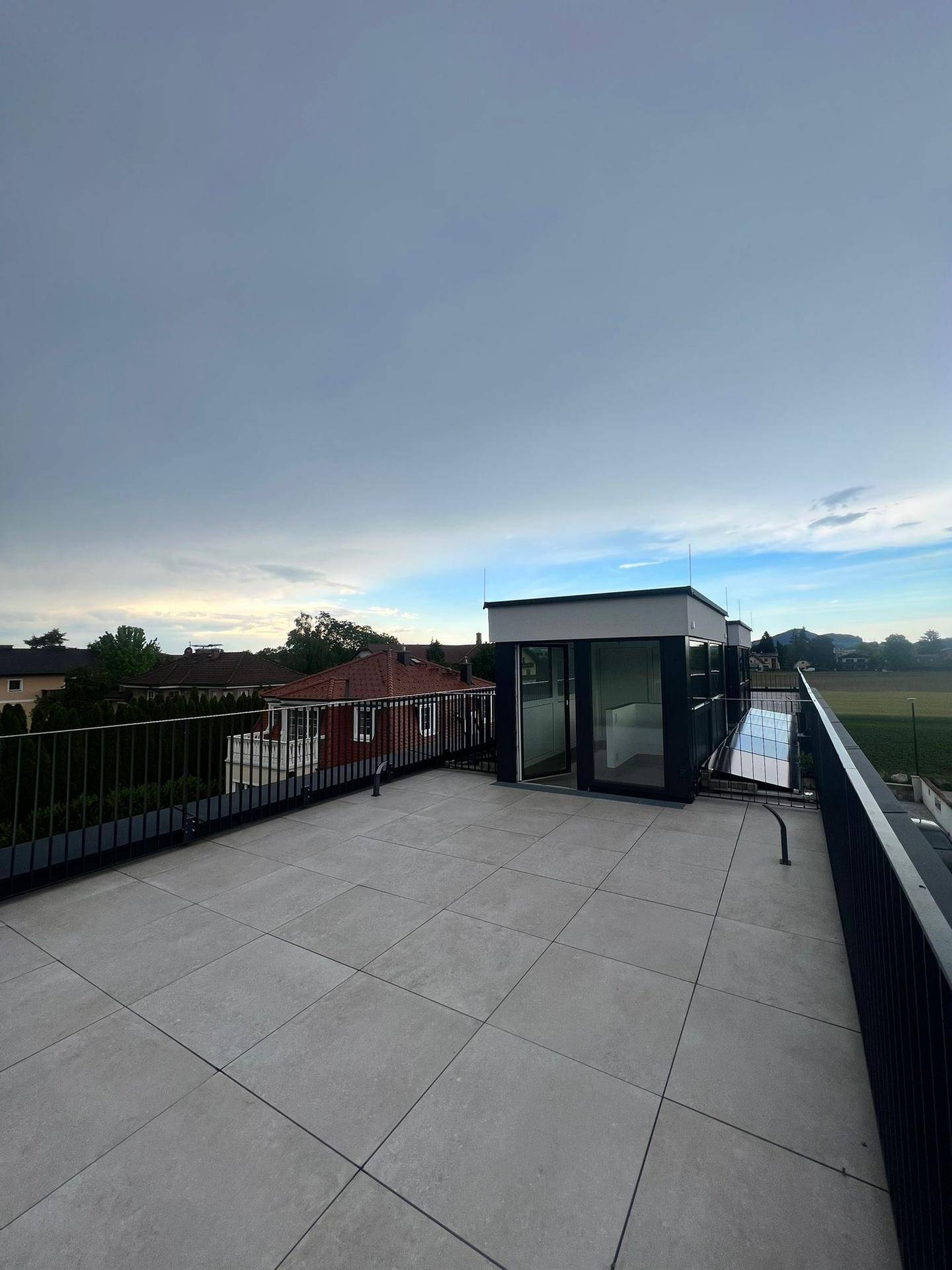 Dachterrasse mit Zugang zum Innenbereich und weitem Blick auf die Landschaft.