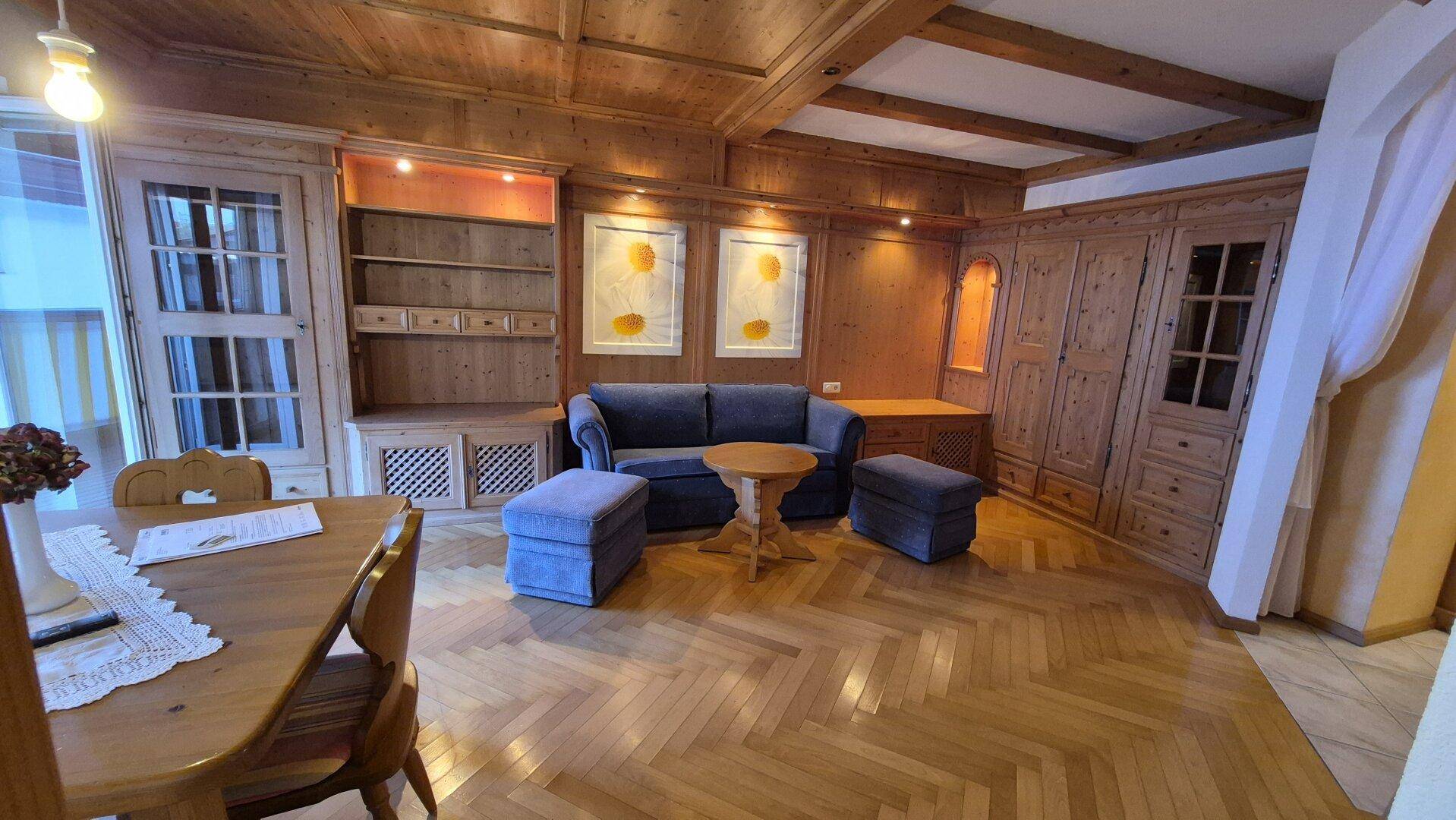 Geräumiger Wohn-Essbereich mit Fischgrätparkett, Holzdecken und traditionellen Holzmöbeln.