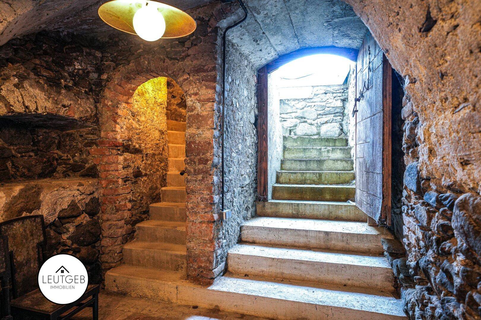 Historischer Keller mit Steinmauern, Gewölbedecken und Steintreppen.