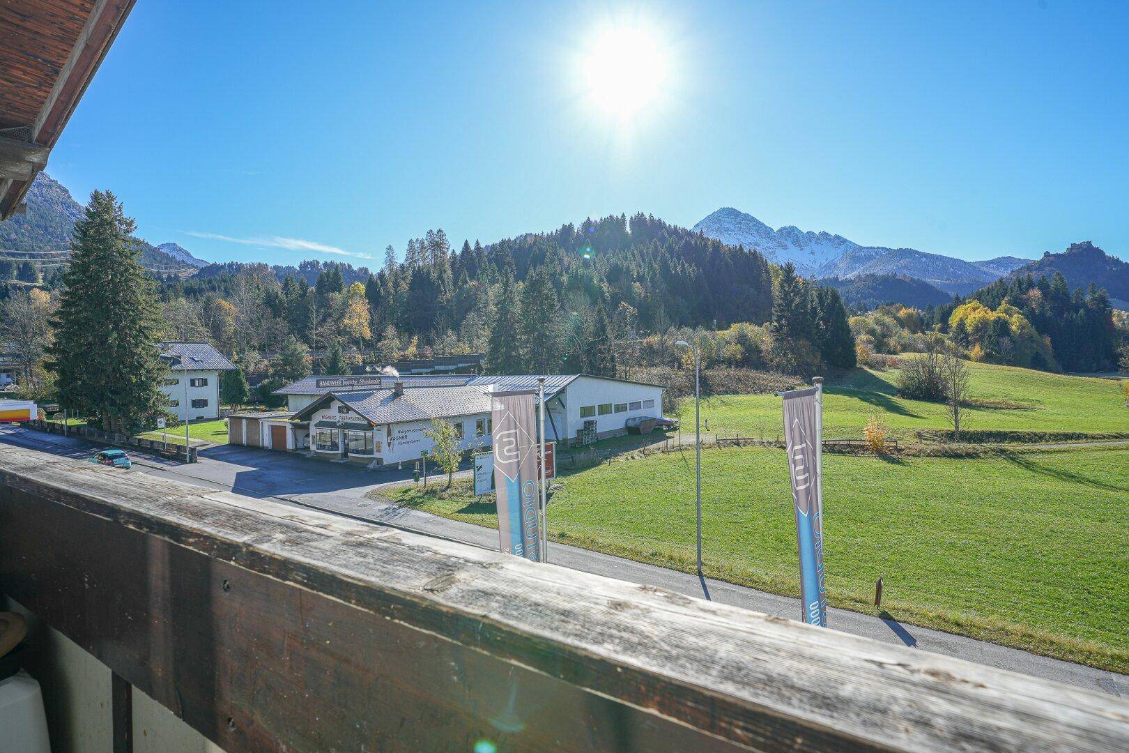 Weitläufiger Panoramablick vom Balkon über die Landschaft mit Bergen und viel Grün.