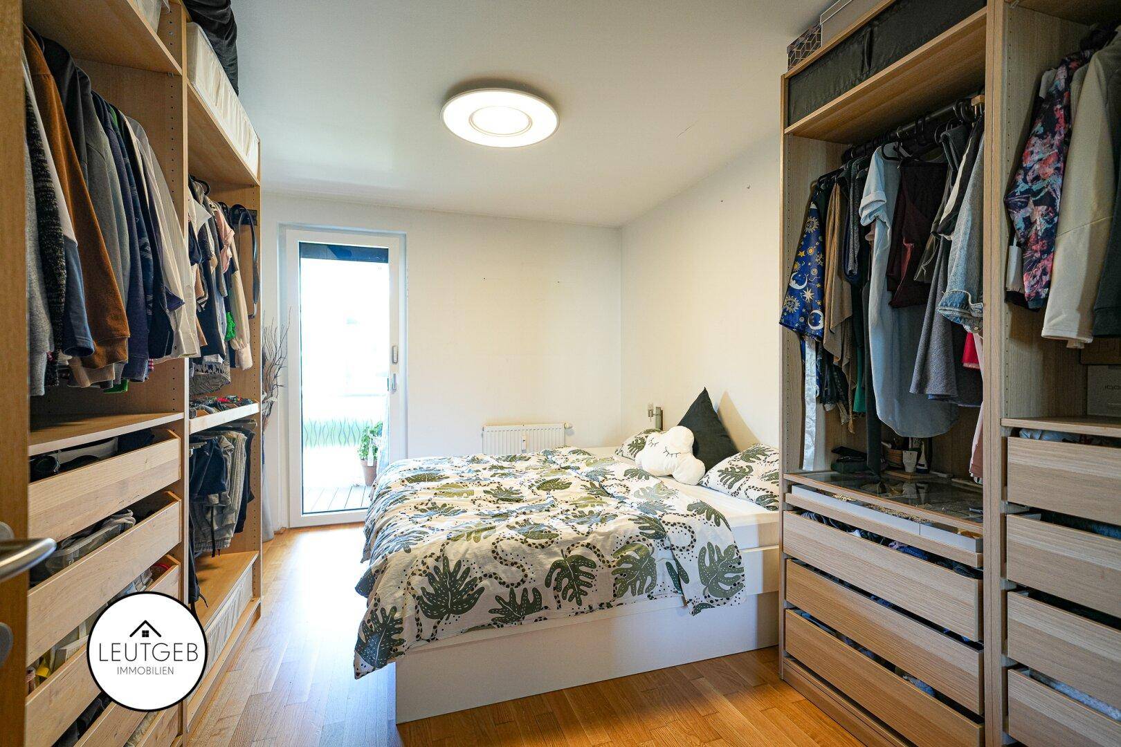 Schlafzimmer mit integrierten offenen Kleiderschränken und Zugang zu einem Außenbereich.