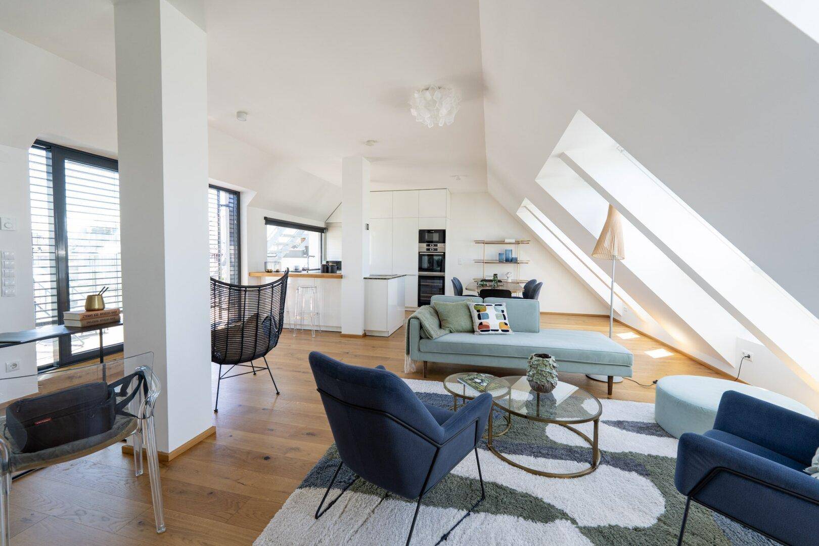 Stilvoller Wohn-Essbereich mit Holzboden, Dachschrägen und moderner Einrichtung.