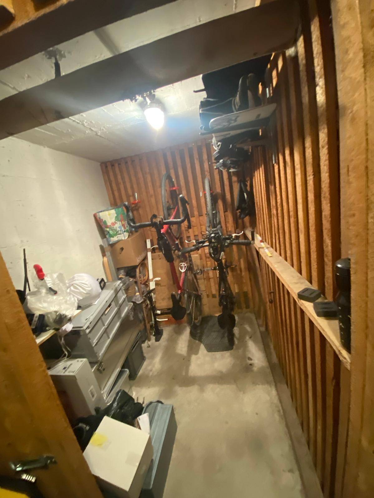 Praktischer Abstellraum mit Holzverkleidung, Regalen und Platz für Fahrräder.