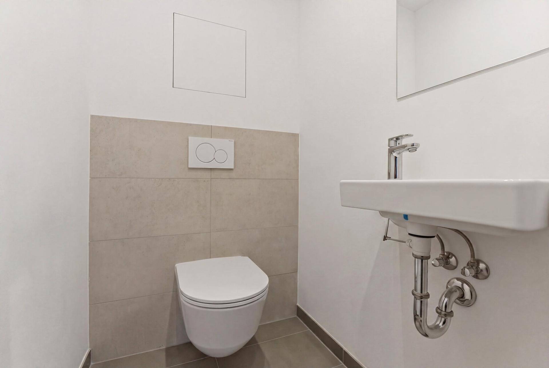 Modernes Gäste-WC mit wandhängender Toilette und kleinem Waschbecken.