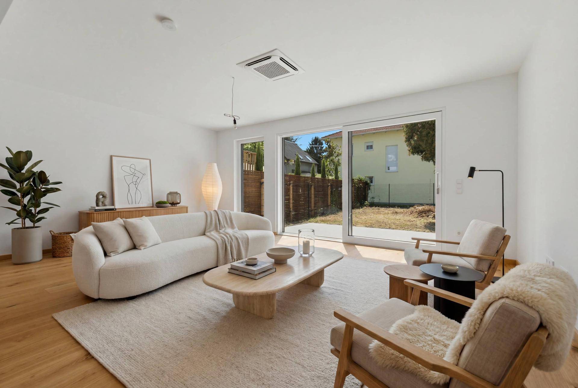 Helles Wohnzimmer mit modernem Mobiliar, Holzboden und direktem Zugang zum Garten.
