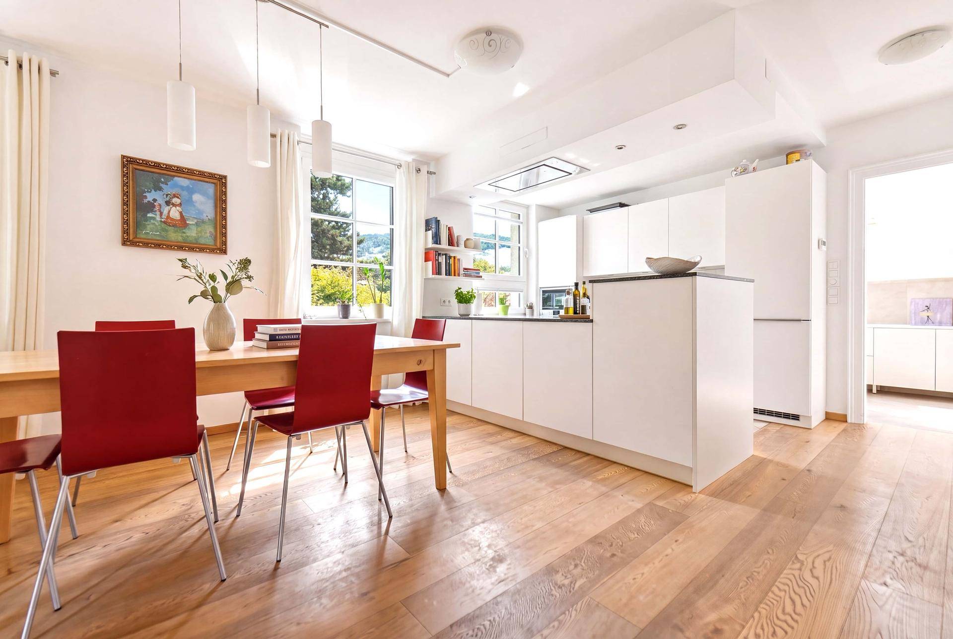 Offener Essbereich mit Holztisch und moderner weißer Küche, ideal für gemeinsame Mahlzeiten.