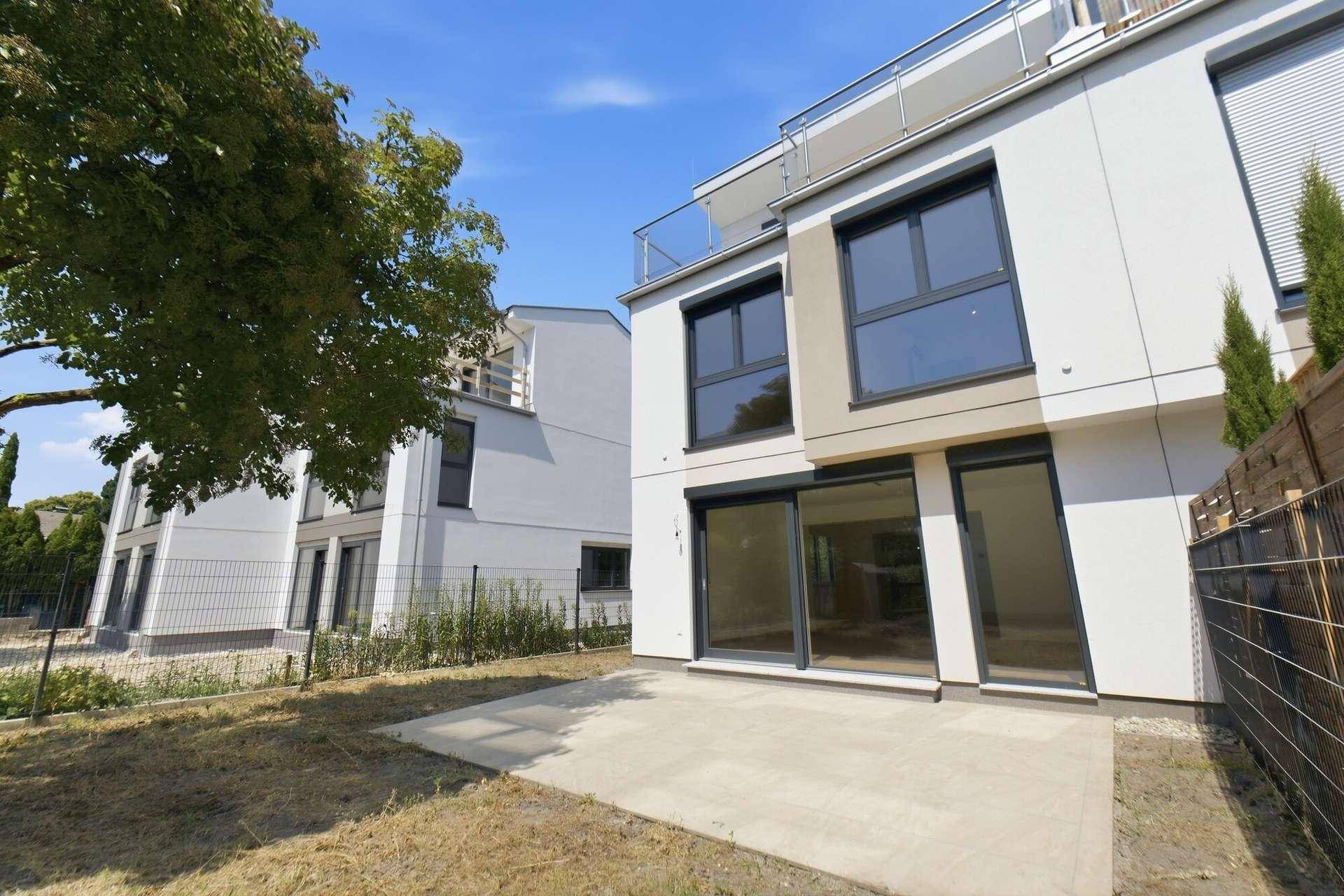 Moderne Reihenhäuser mit Terrasse und Gartenbereich, ideal für entspannte Stunden im Freien.