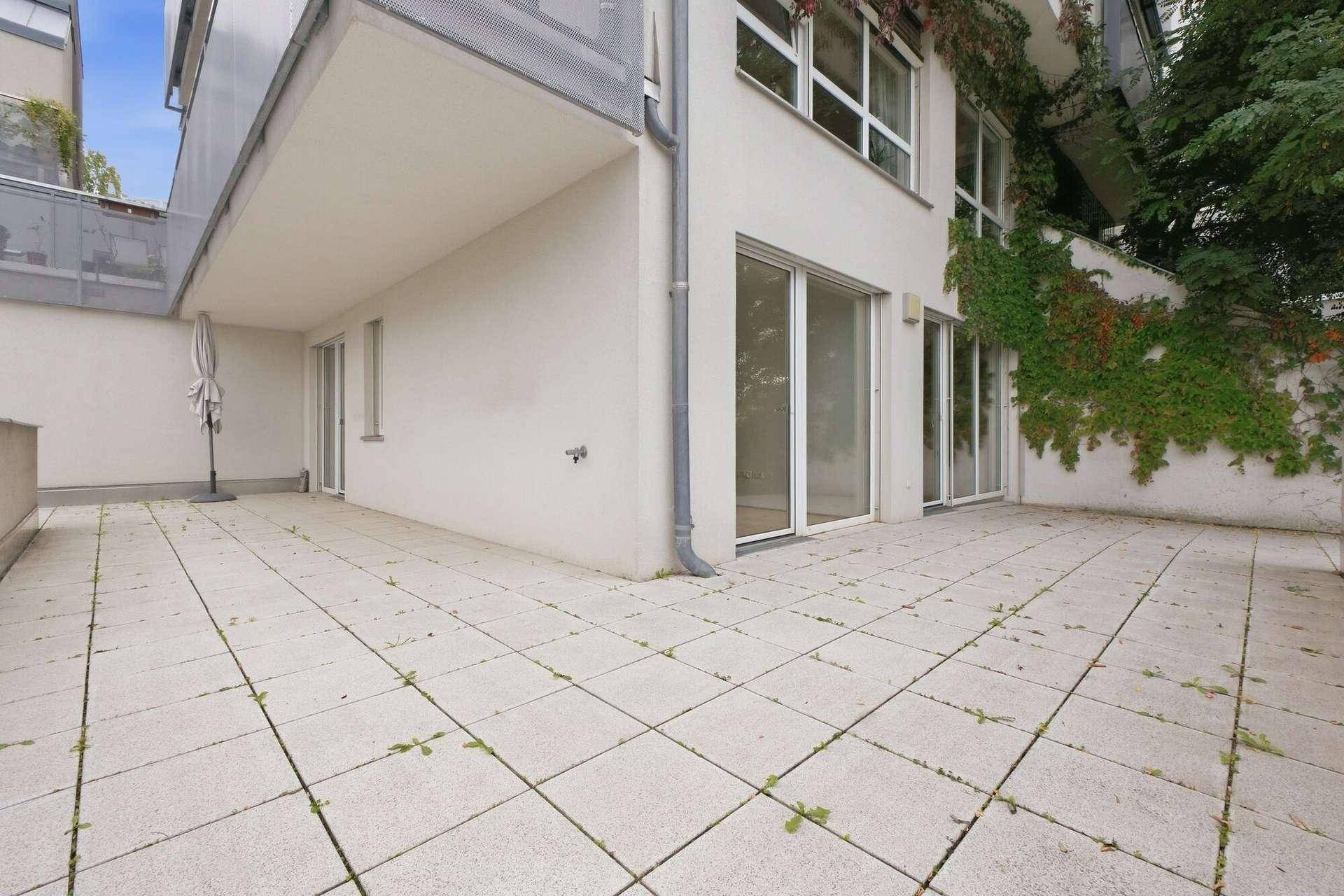 Geräumige, geflieste Terrasse mit viel Tageslicht und Zugang zu den Innenräumen.