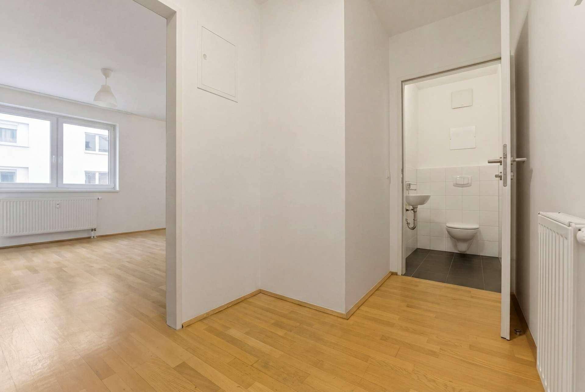 Flur mit Parkettboden und Zugang zu einem separaten Gäste-WC.