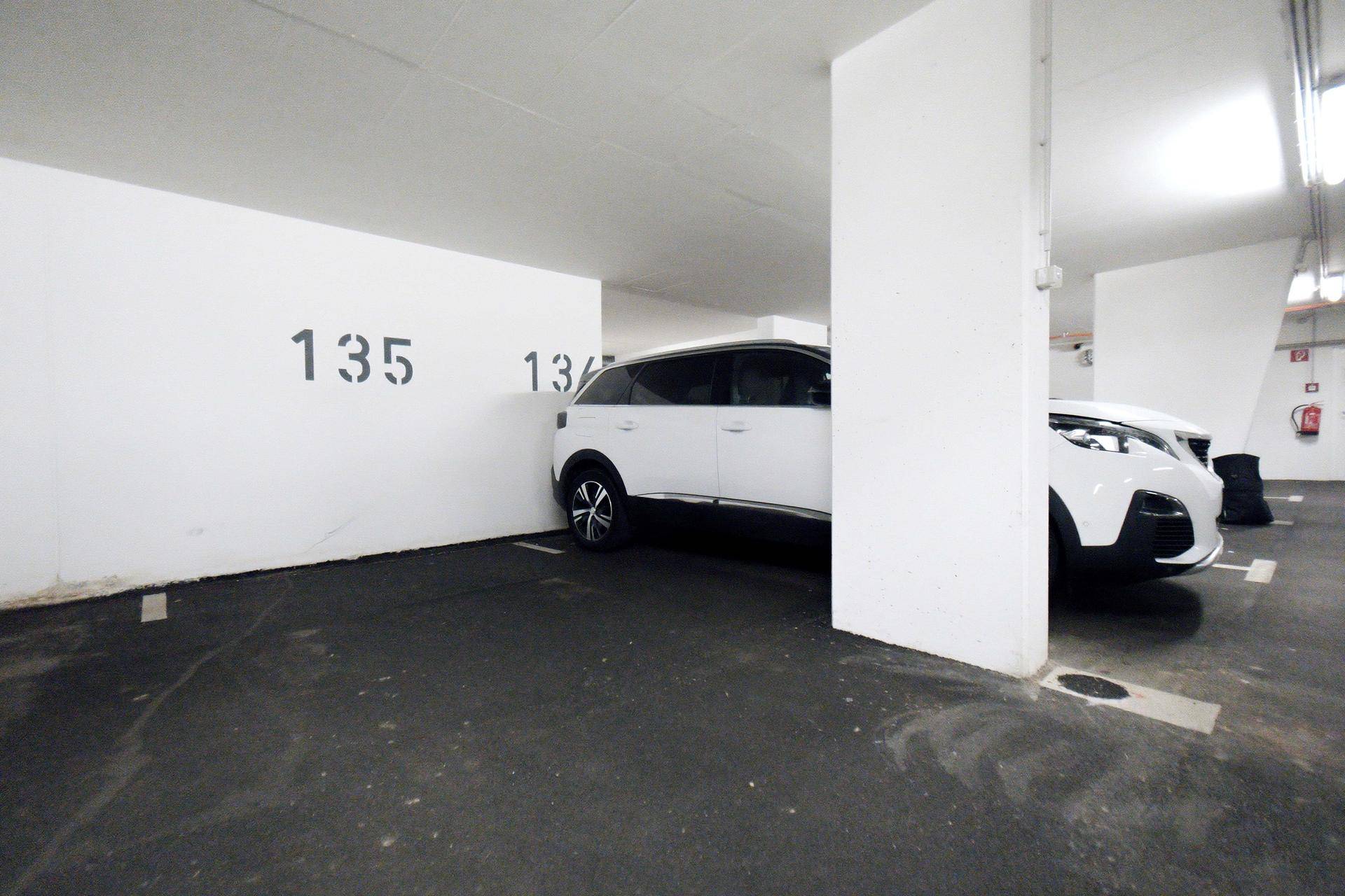 Tiefgaragenstellplatz mit Nummerierung an der Wand und einem weißen SUV.