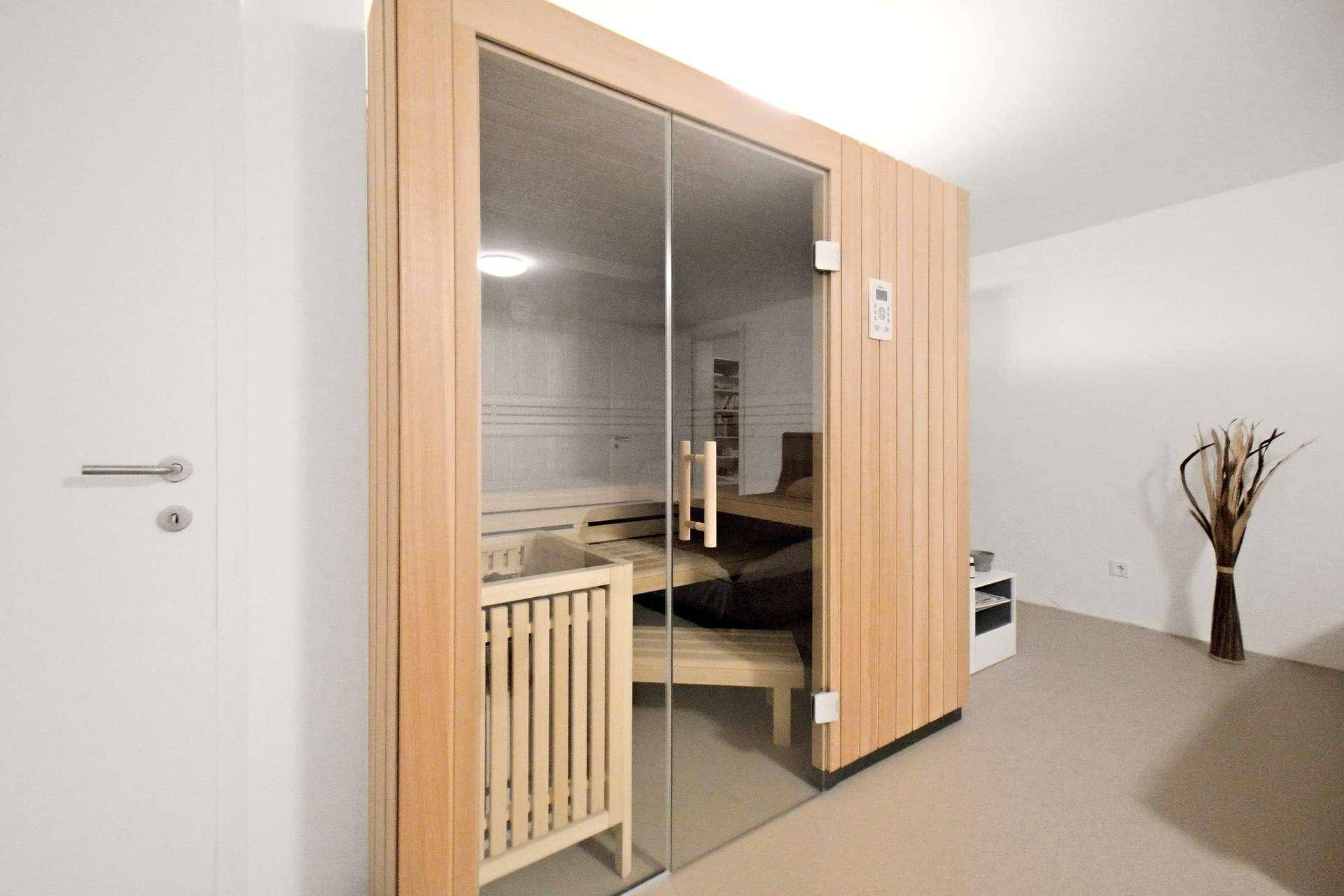 Hochwertige Sauna mit Glasfront und Holzbänken für entspannende Momente.