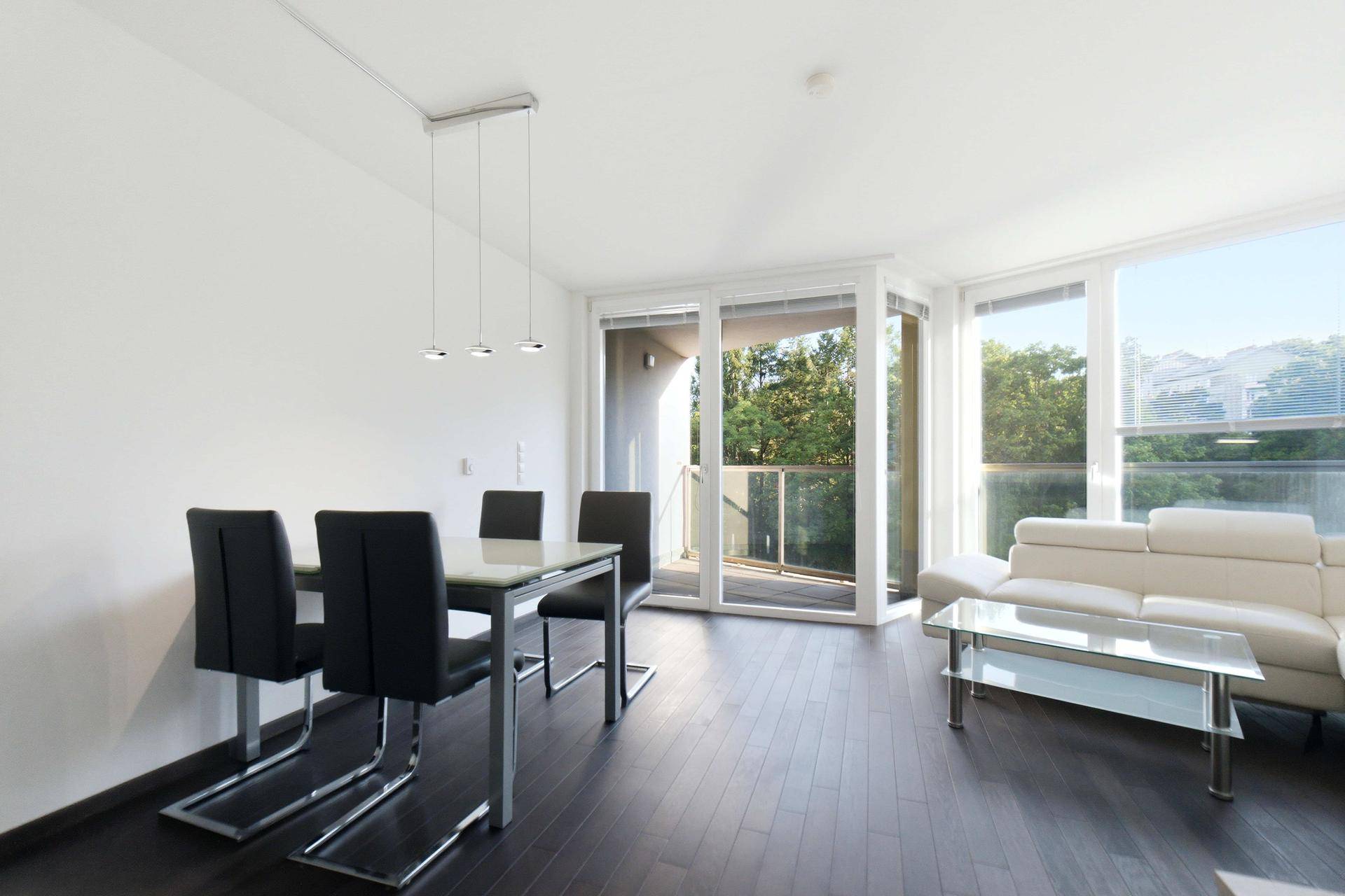 Heller Essbereich mit modernem Tisch und Stühlen, offen zum Wohnzimmer und Balkonzugang.