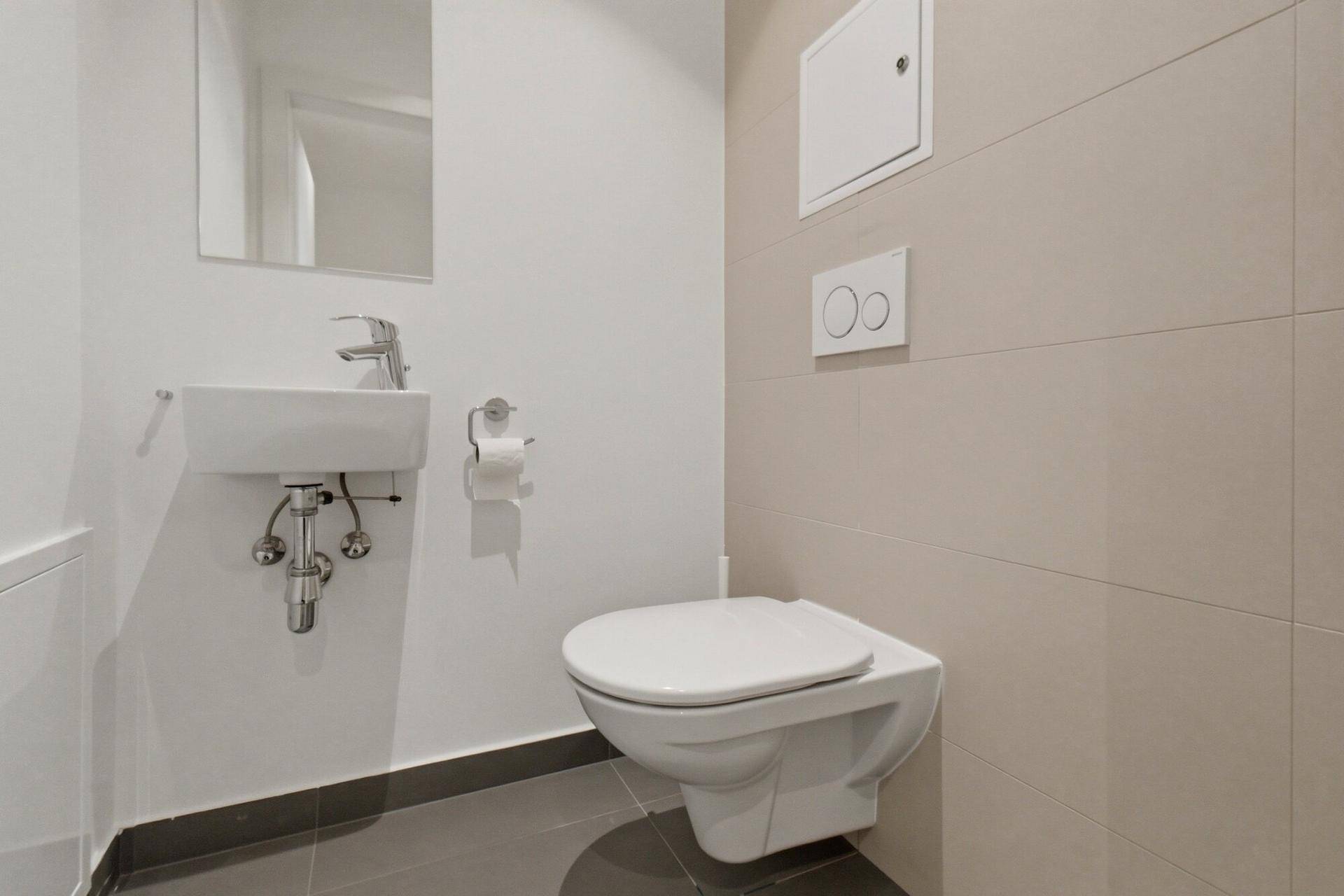 Funktionelles Gäste-WC mit wandhängender Toilette und kleinem Waschbecken.