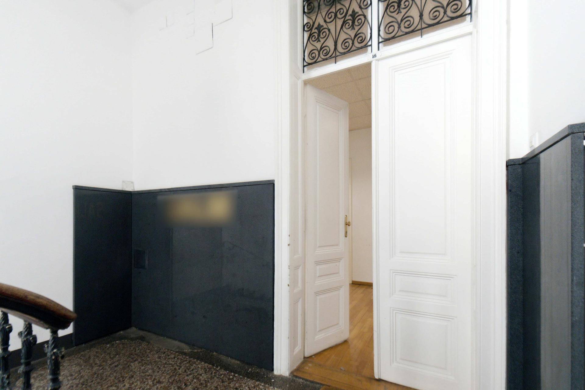 Heller Flur mit weißer Doppeltür und Blick in die angrenzenden Wohnräume.