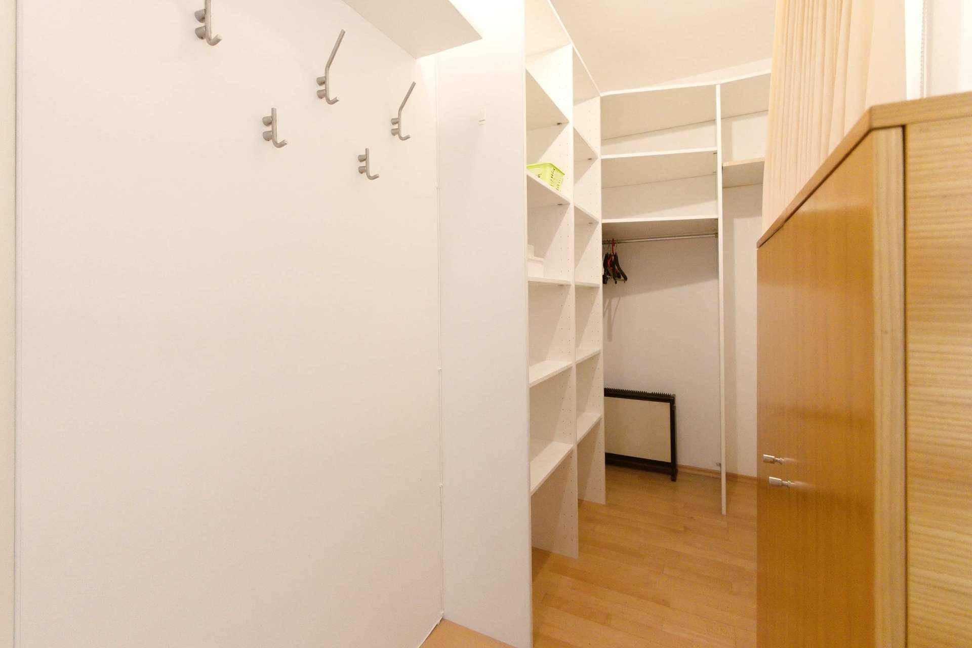 Gut organisierter begehbarer Kleiderschrank mit vielen Regalen und Stauraummöglichkeiten.