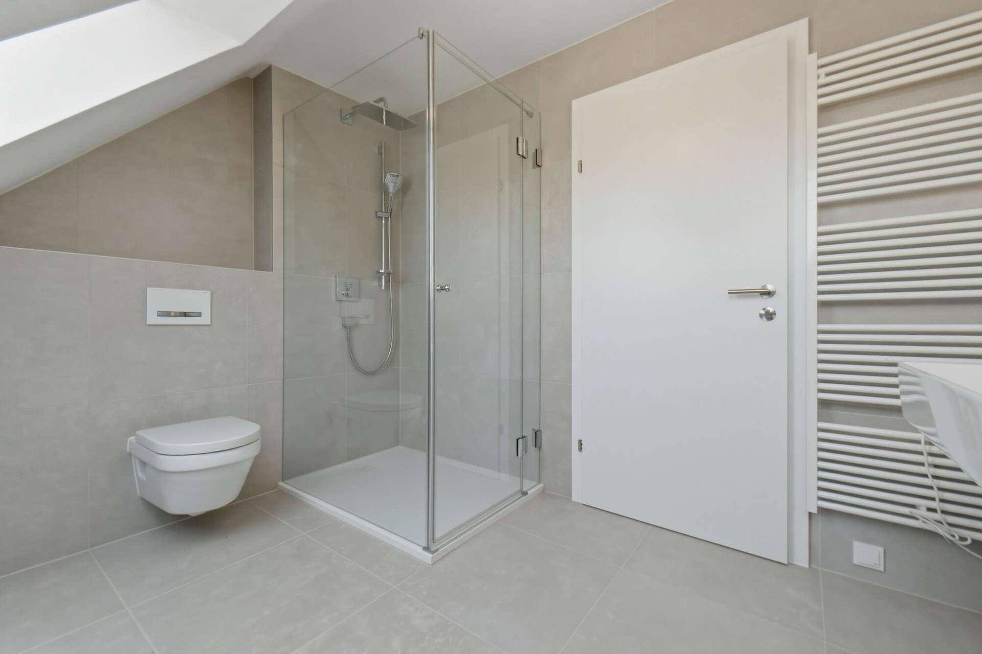 Modernes Badezimmer im Dachgeschoss mit begehbarer Dusche, Hänge-WC und Dachschräge.