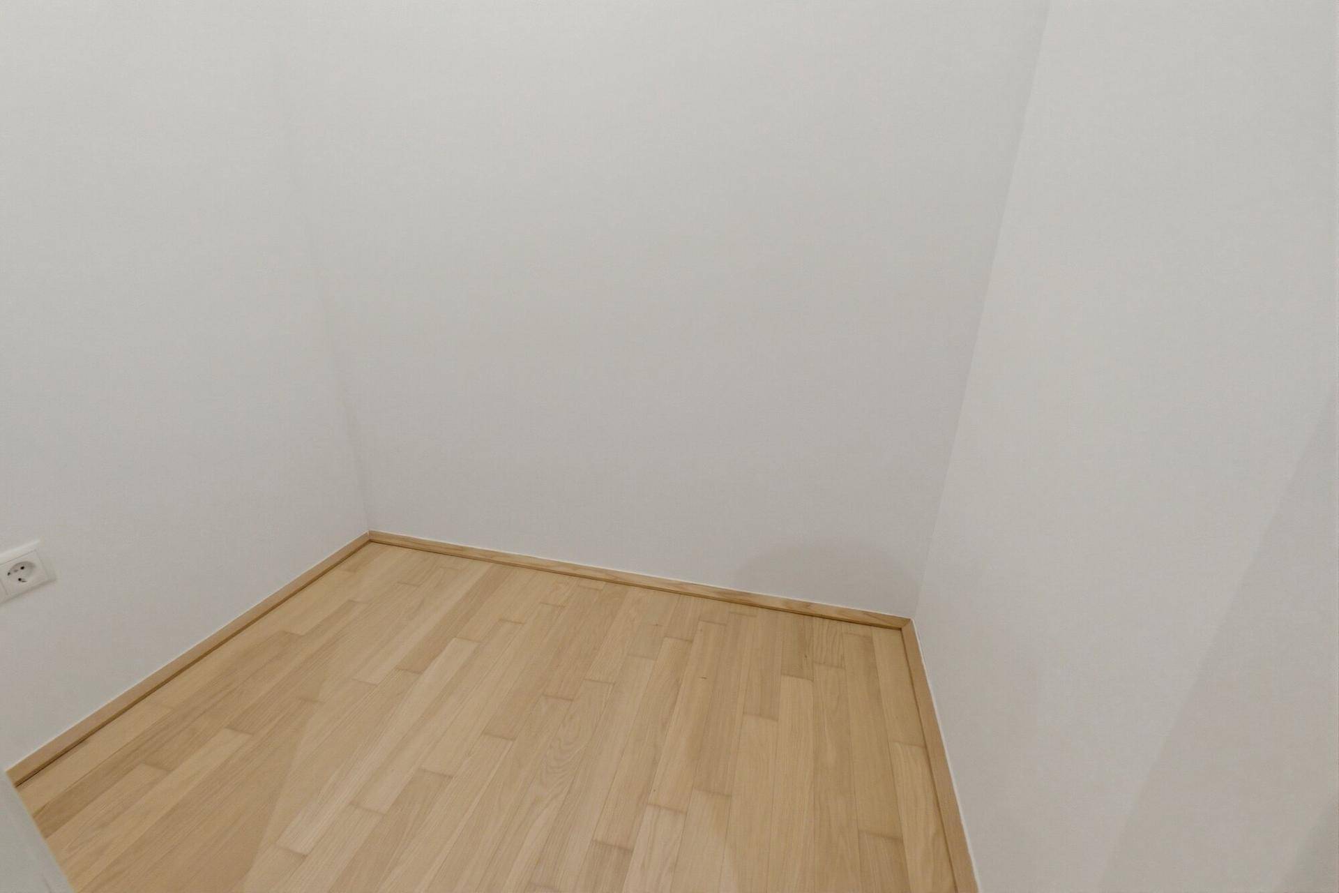 Kleiner, heller Raum mit Holzboden, ideal als Abstellraum oder kleines Büro nutzbar.