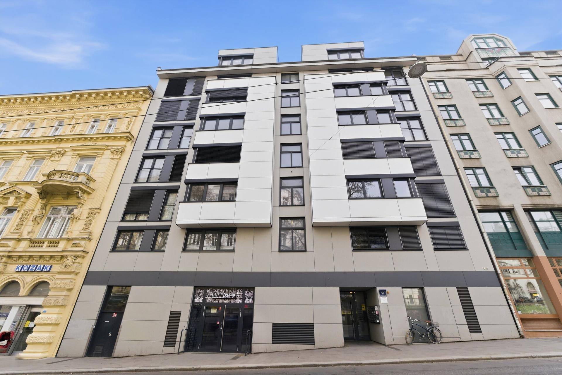Ansicht der modernen Wohnhausfassade mit klaren Linien und großen Fenstern.