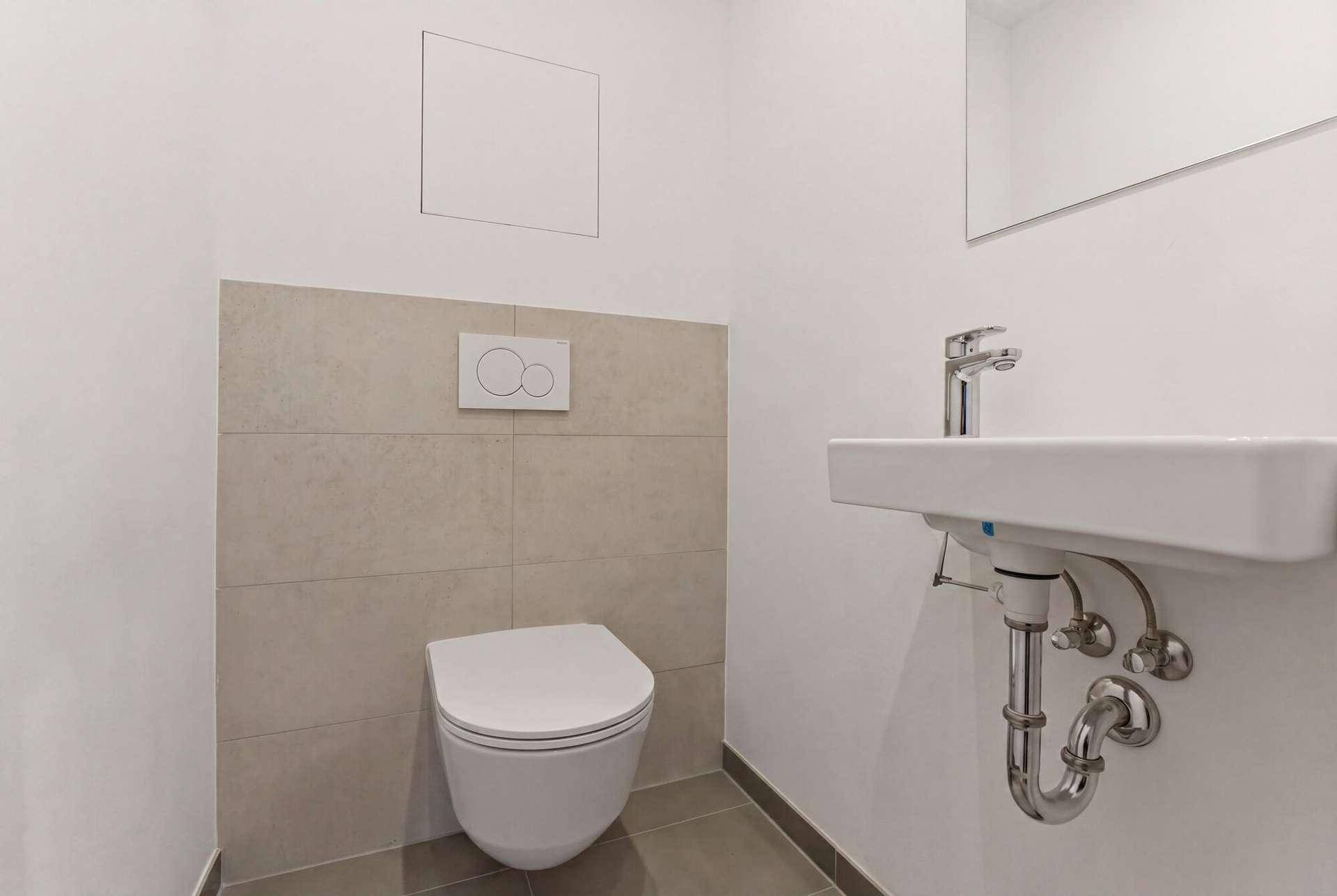 Modernes Gäste-WC mit wandhängender Toilette und kleinem Waschbecken.
