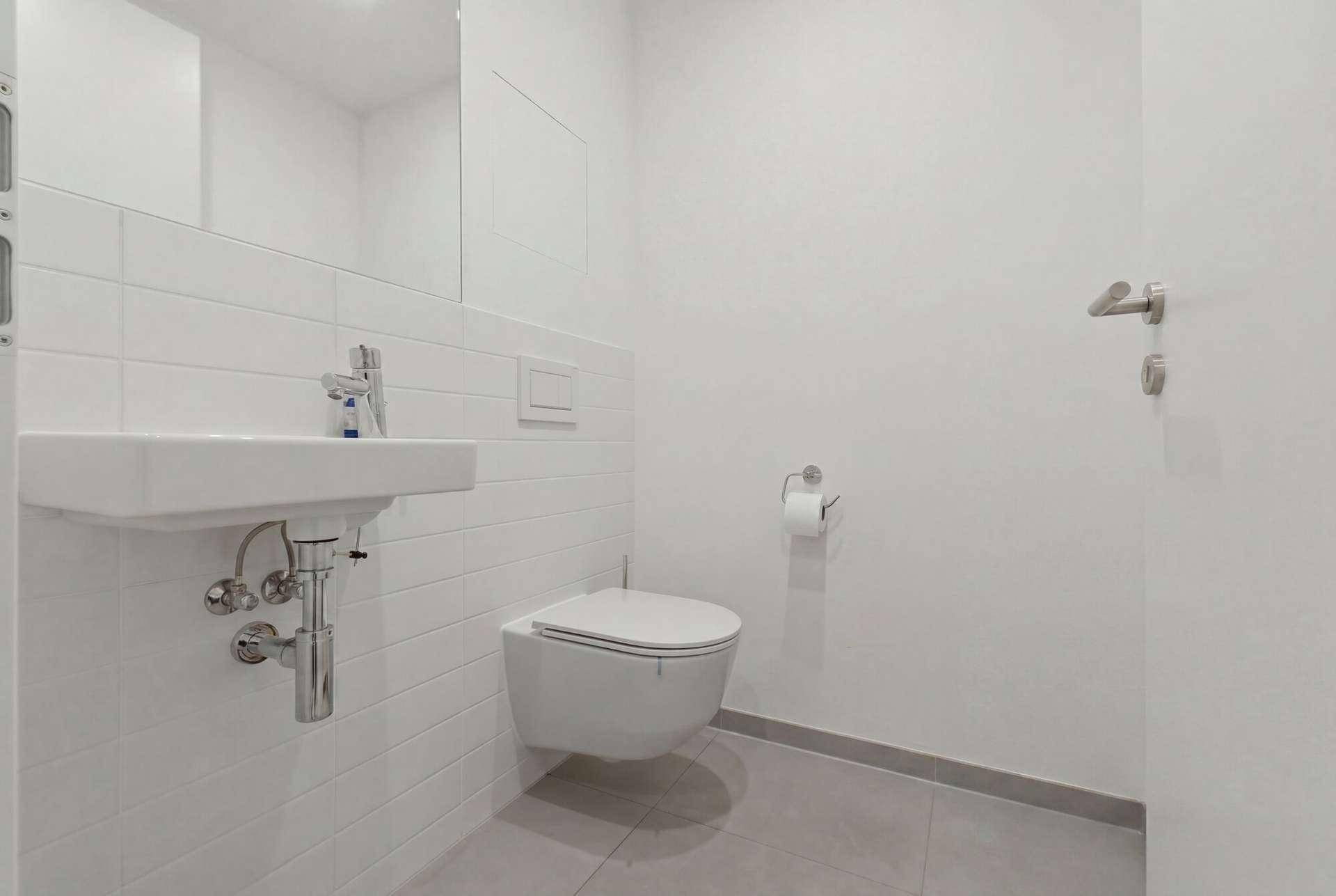 Helles Gäste-WC mit wandhängendem WC und modernem Waschbecken.