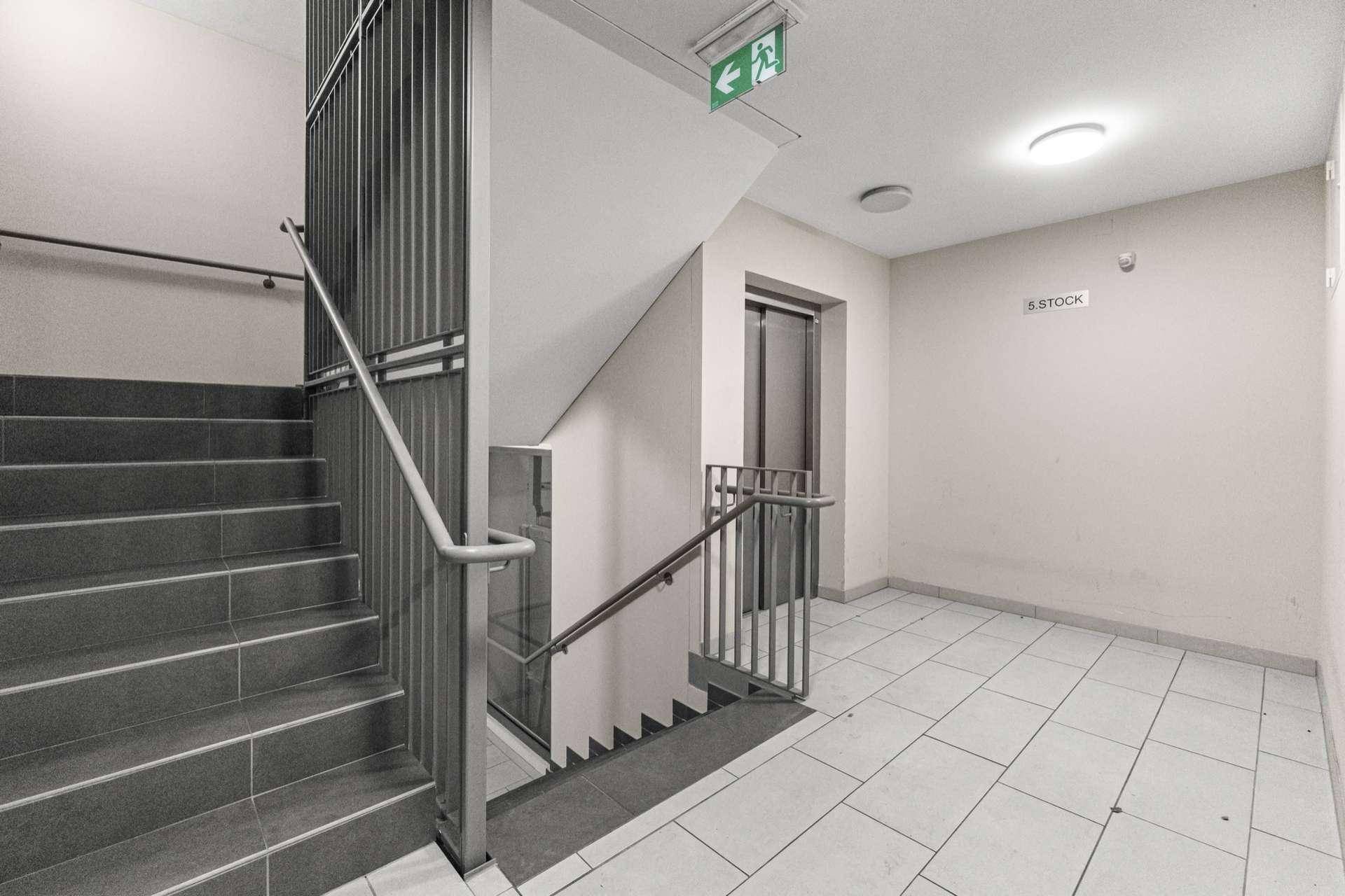 Treppenhaus mit Aufzug und Zugang zu den oberen Stockwerken.