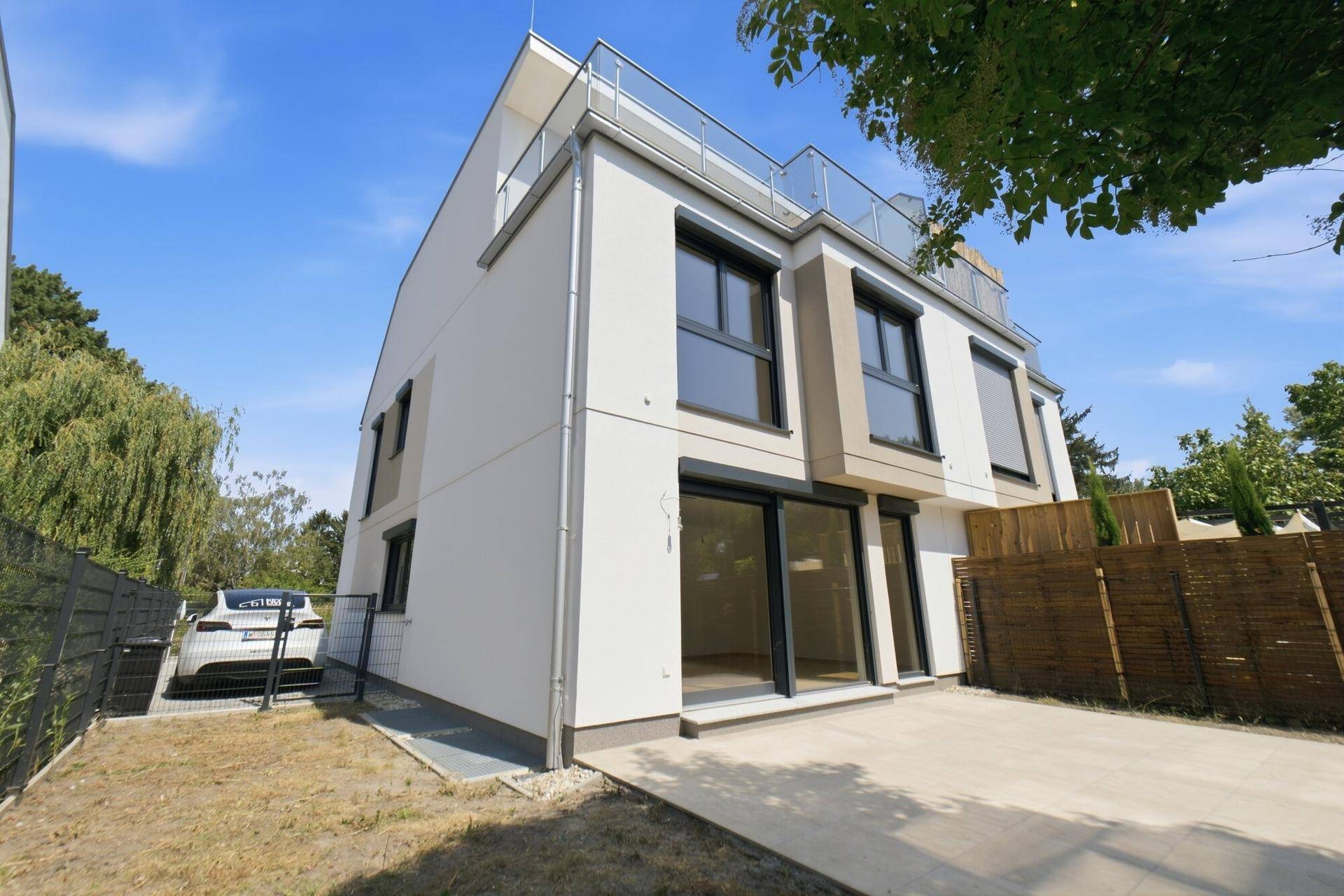Moderne Doppelhaushälfte mit großen Fenstern und Zugang zum Gartenbereich.