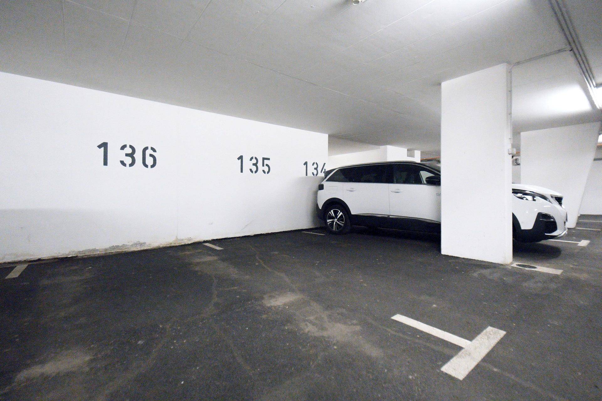 Tiefgaragenstellplatz mit Nummerierung an der Wand und einem weißen SUV.