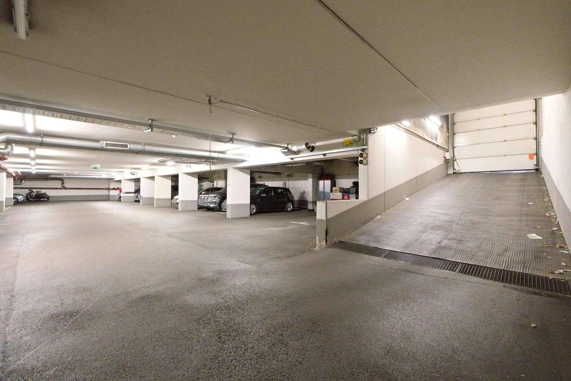Geräumige Tiefgarage mit Zufahrtsrampe und mehreren Parkplätzen für Bewohner.