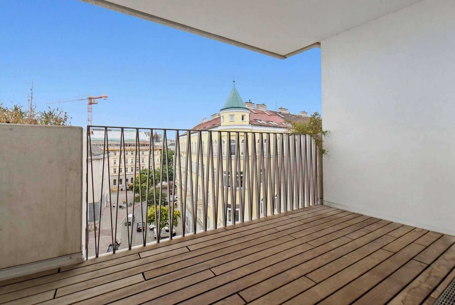 Geräumiger Balkon mit Holzboden und Blick auf die Stadt.