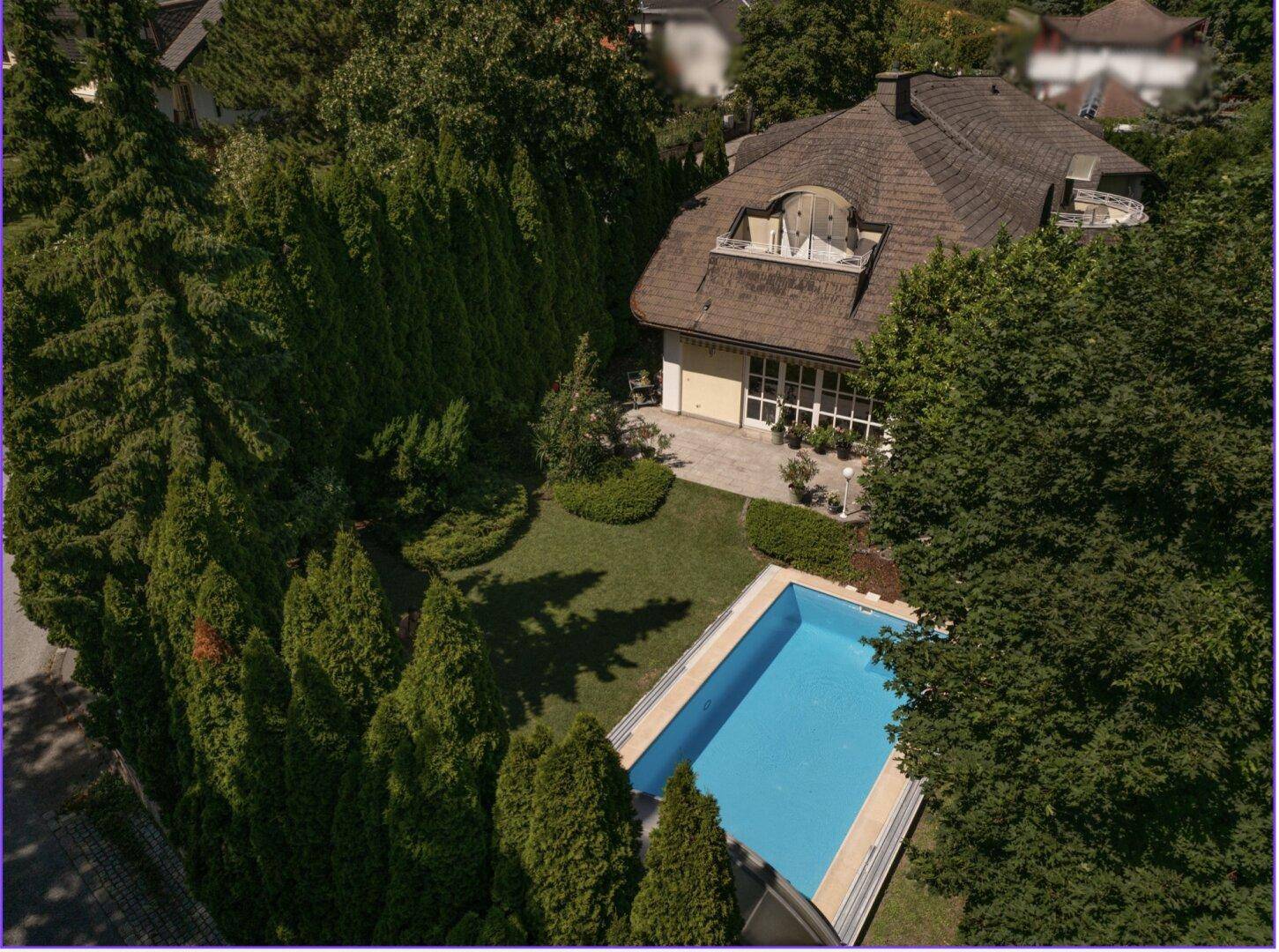 Luftaufnahme des Anwesens mit Villa, Pool und dicht bewachsenem, gepflegtem Garten.