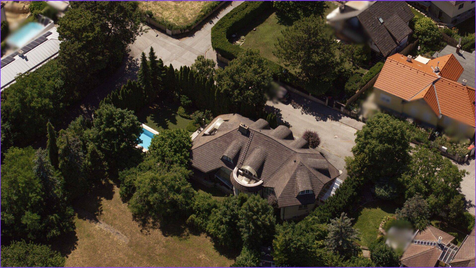 Luftaufnahme des Anwesens mit Pool und umliegender Wohngegend, eingebettet in viel Grün.