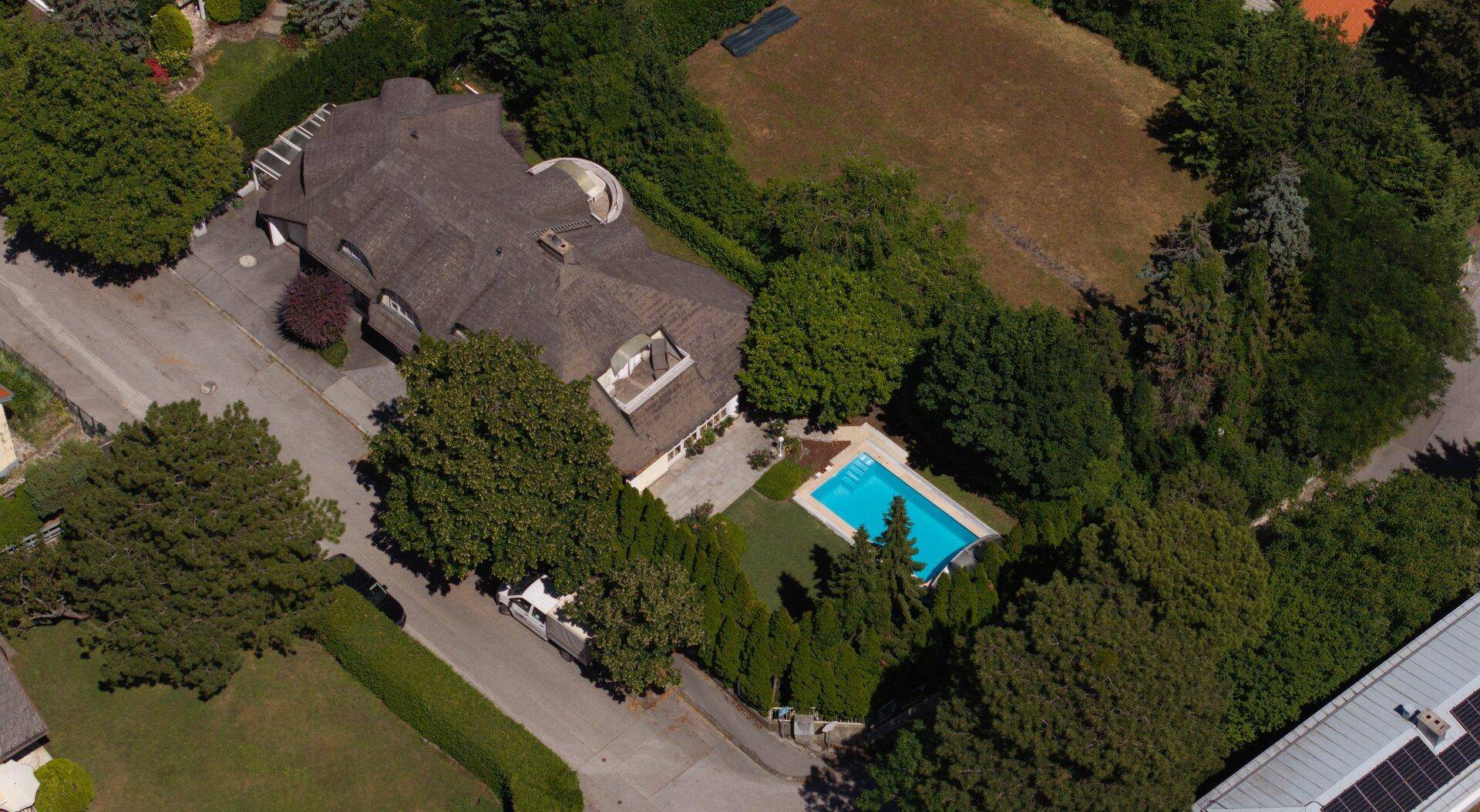 Weitläufige Luftaufnahme des Anwesens mit Villa, Pool und umgebender grüner Landschaft.