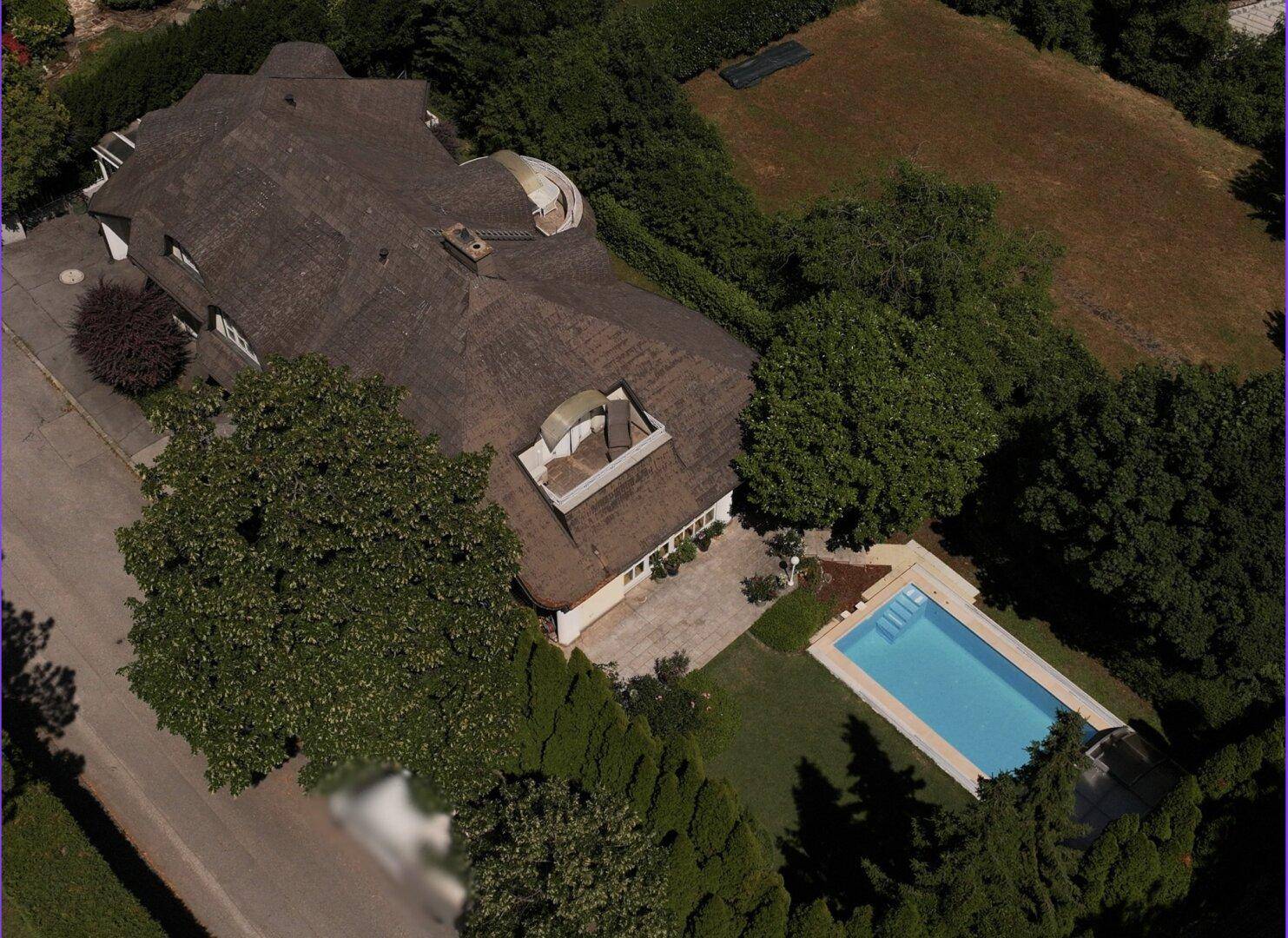 Weitläufige Luftaufnahme des Anwesens mit Villa, Pool und umgebender grüner Landschaft.