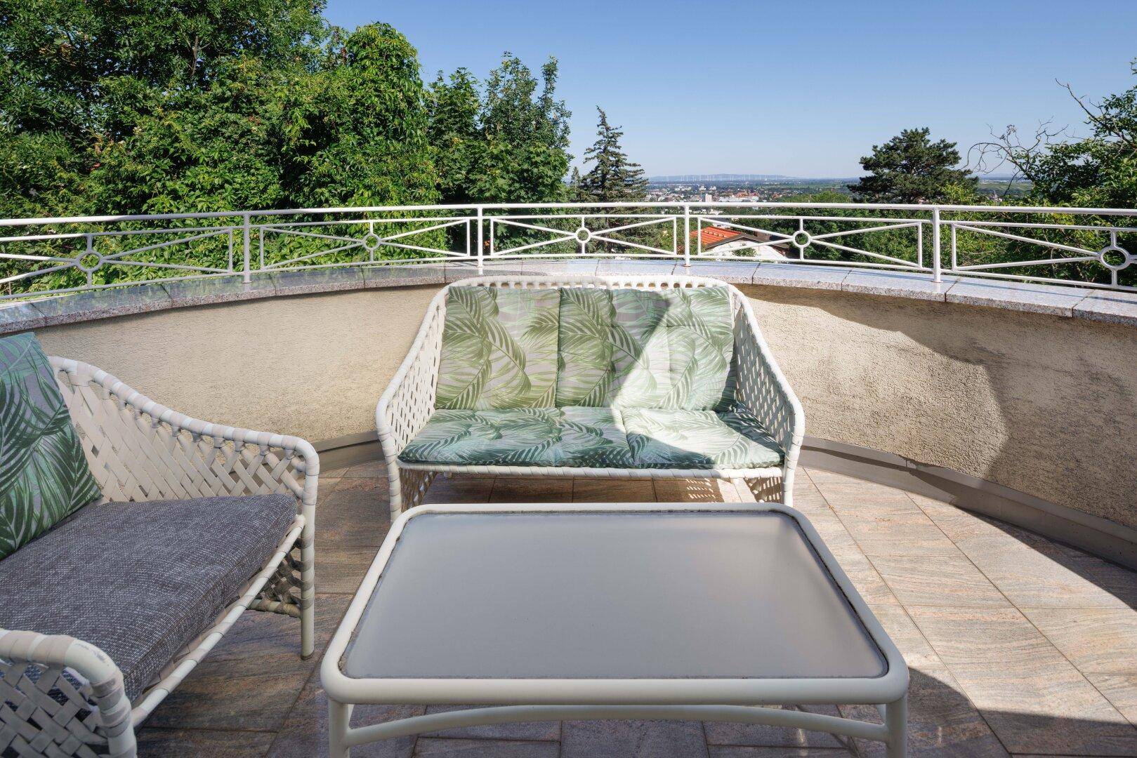 Großer Balkon mit Sitzgelegenheiten und weitem Blick über die umliegende Landschaft.
