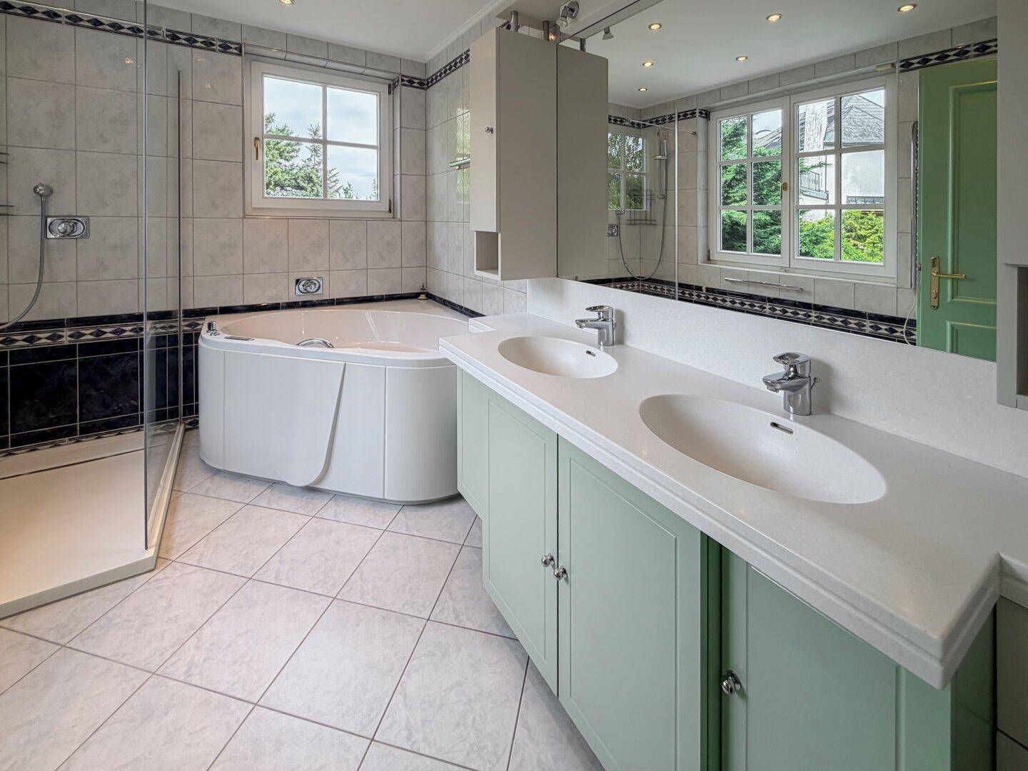 Geräumiges Badezimmer mit Doppelwaschbecken, Eckbadewanne und separater Dusche.