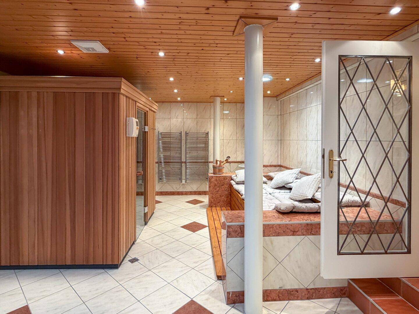 Wellnessbereich im Untergeschoss mit Sauna, Liegeflächen und Fliesenboden.